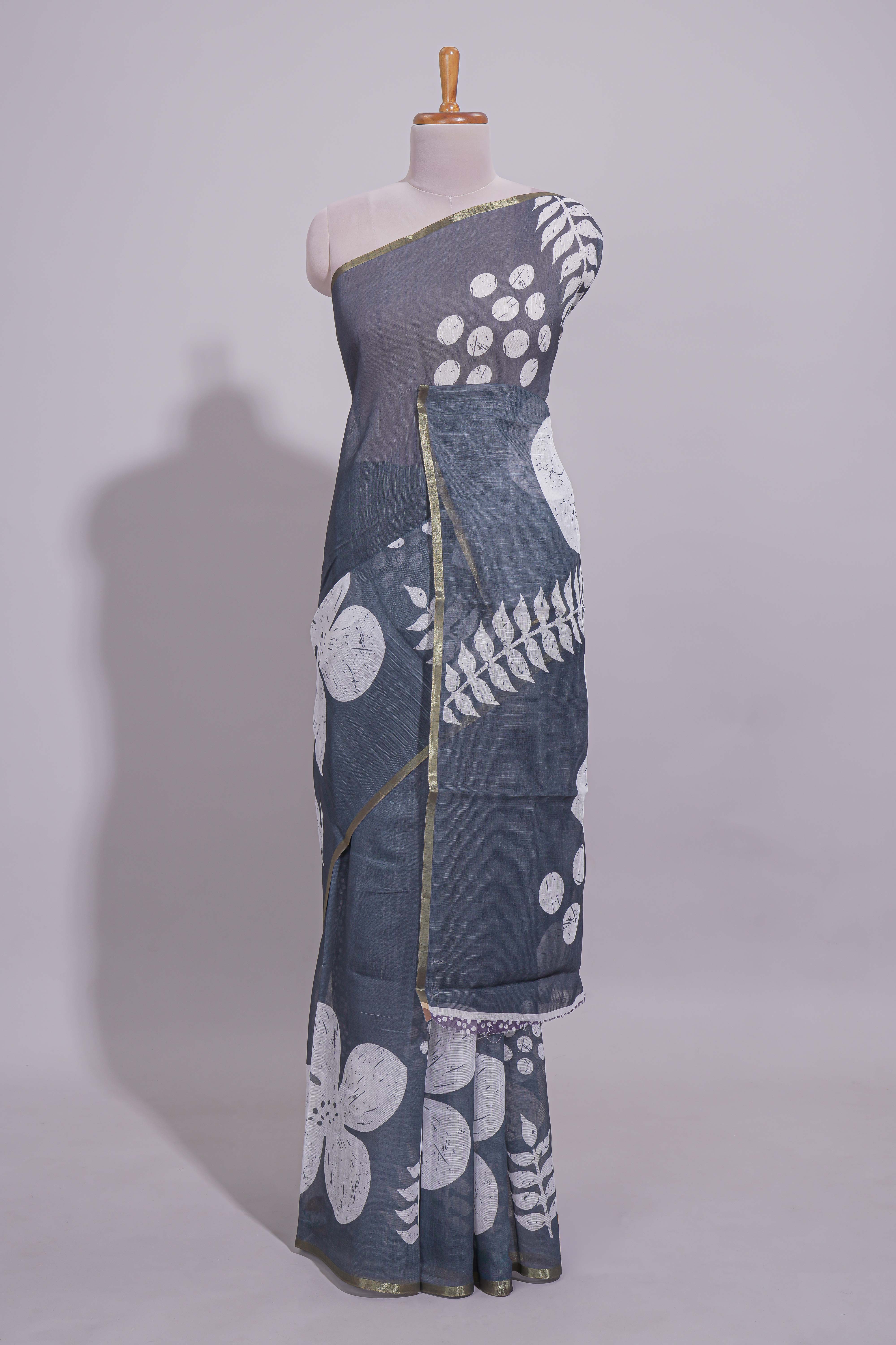 Charcoal grey linen saree with bold white floral and geometric prints finished with a subtle metallic border along with matching blouse