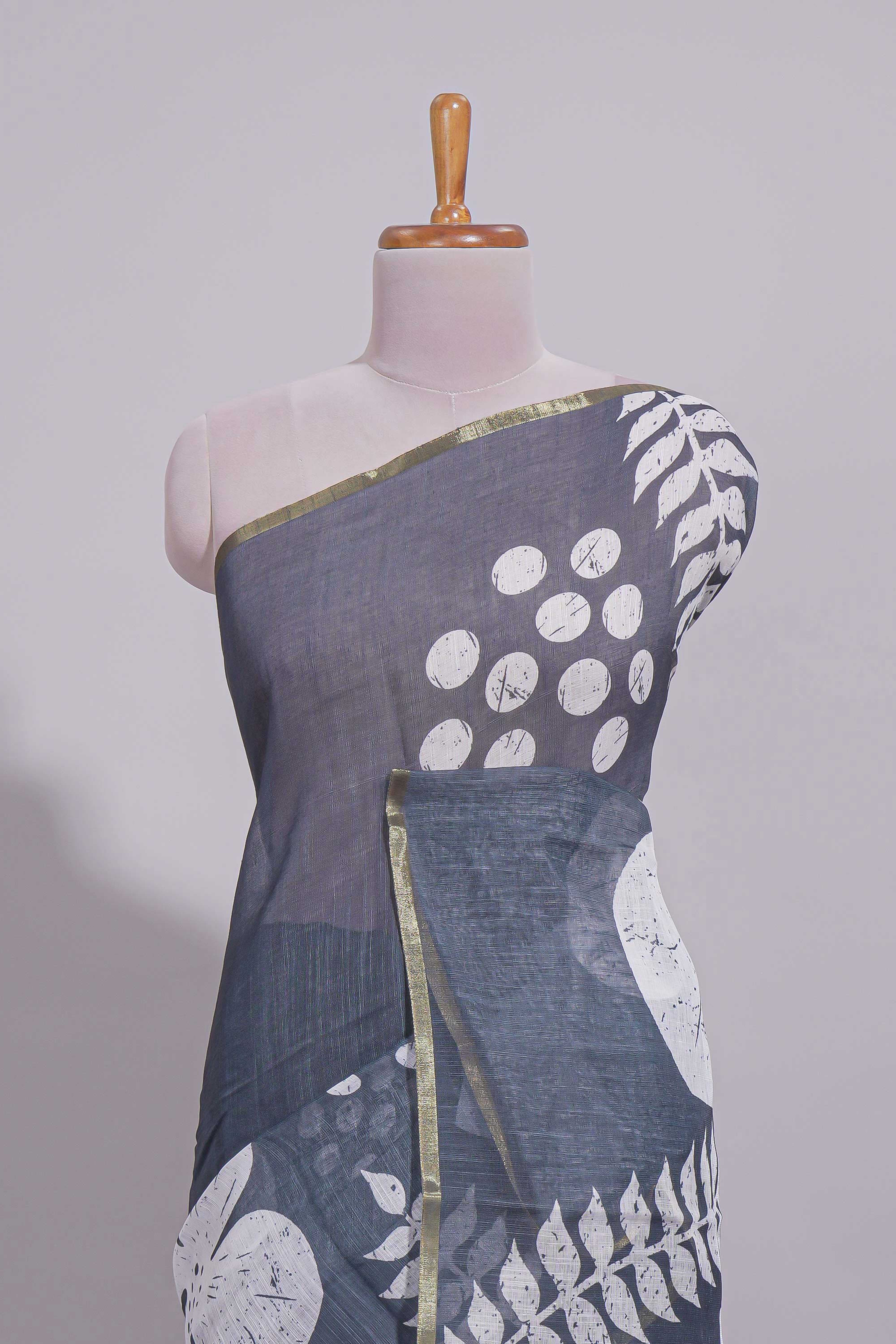 Charcoal grey linen saree with bold white floral and geometric prints finished with a subtle metallic border along with matching blouse