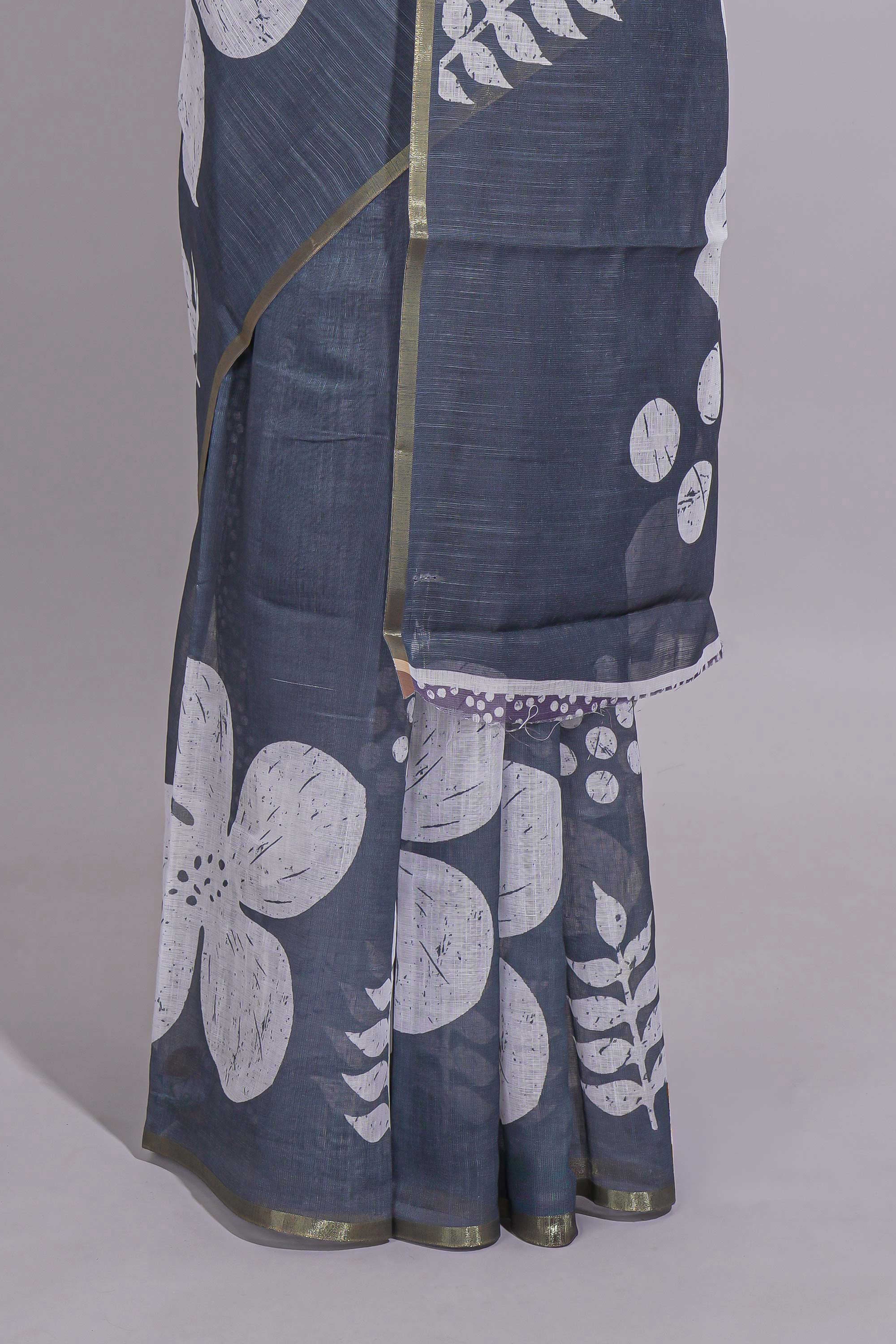 Charcoal grey linen saree with bold white floral and geometric prints finished with a subtle metallic border along with matching blouse