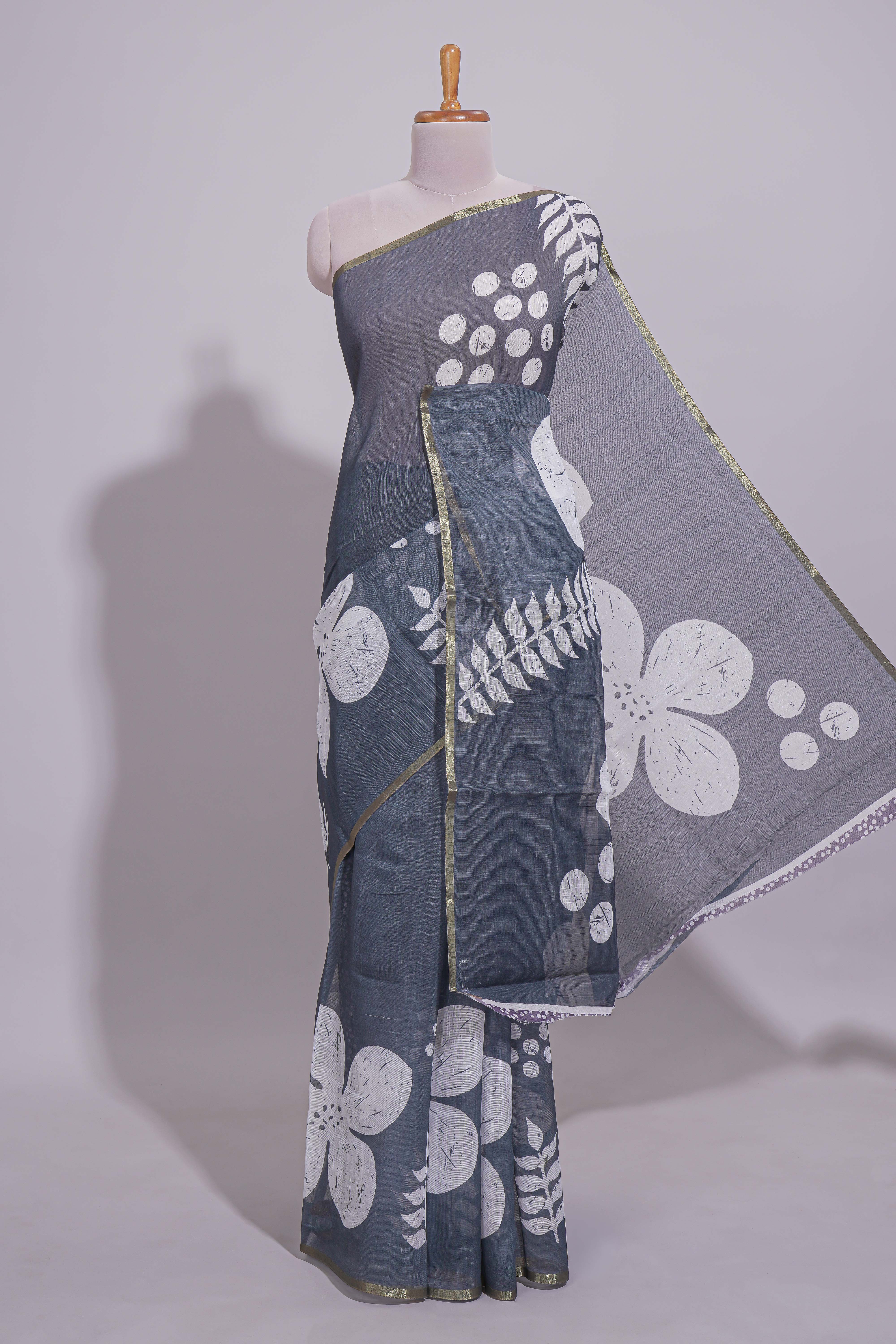 Charcoal grey linen saree with bold white floral and geometric prints finished with a subtle metallic border along with matching blouse