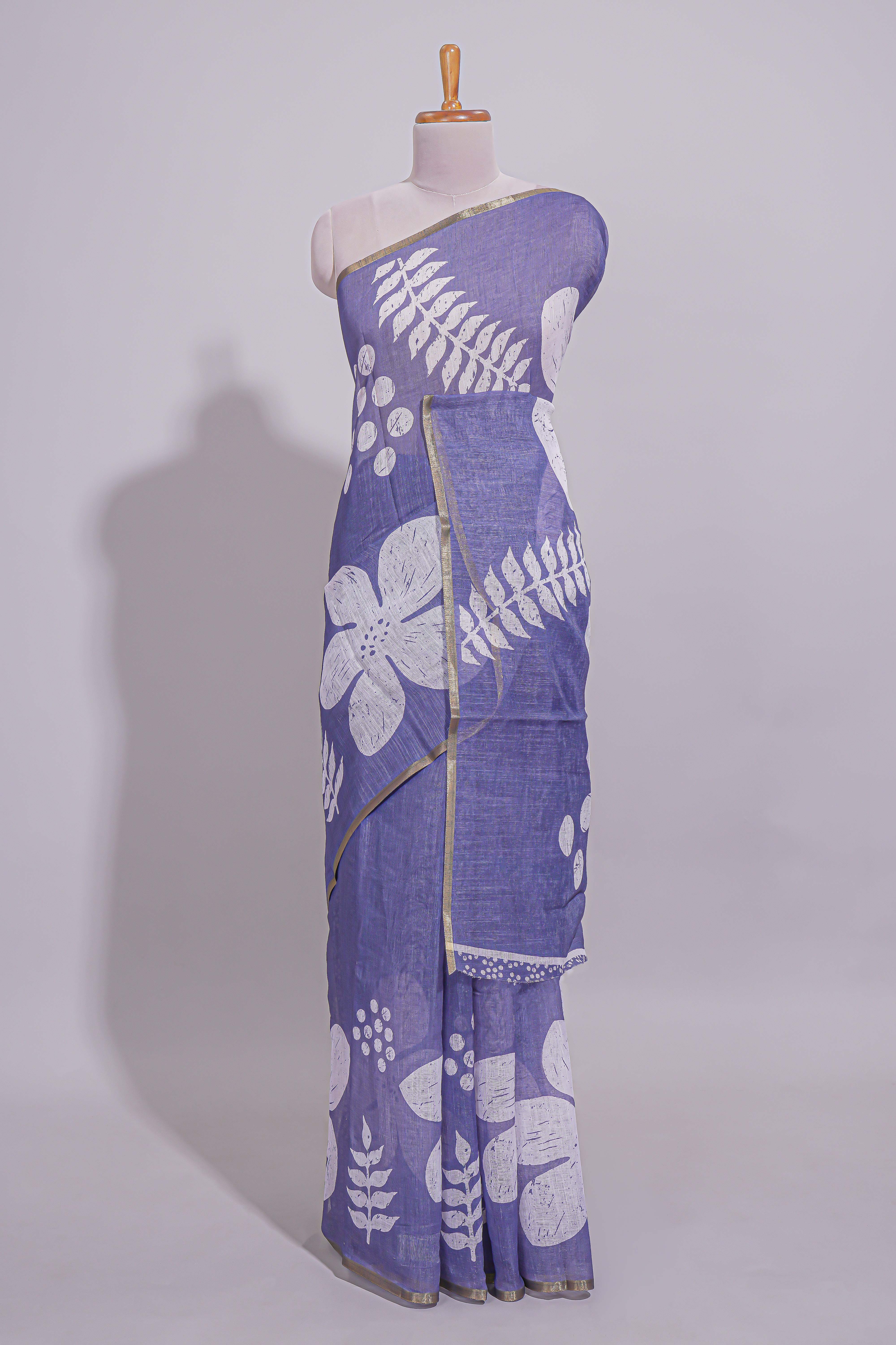 Tropical indigo linen saree with bold white floral and geometric prints finished with a subtle metallic border along with matching blouse