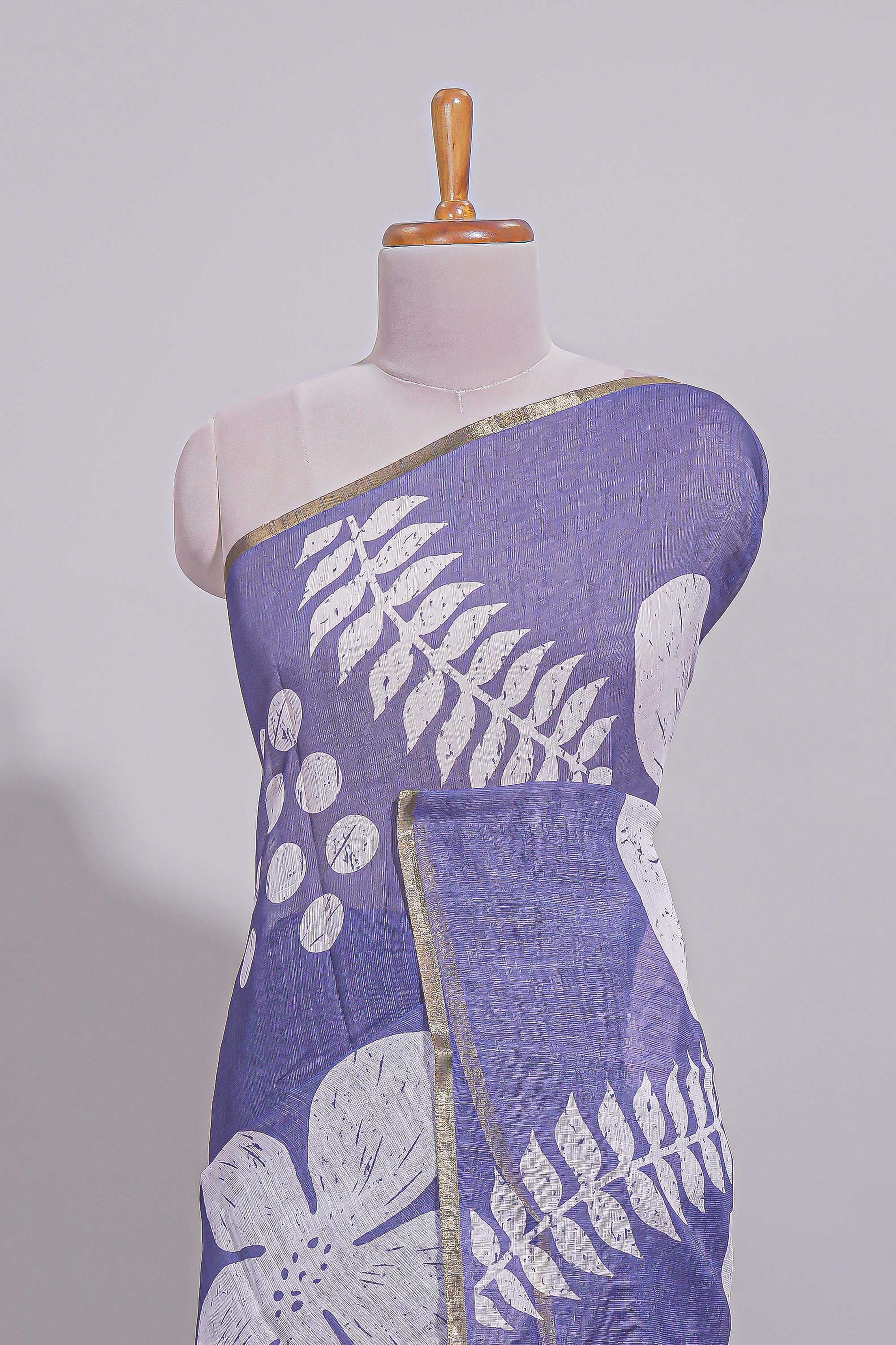 Tropical indigo linen saree with bold white floral and geometric prints finished with a subtle metallic border along with matching blouse