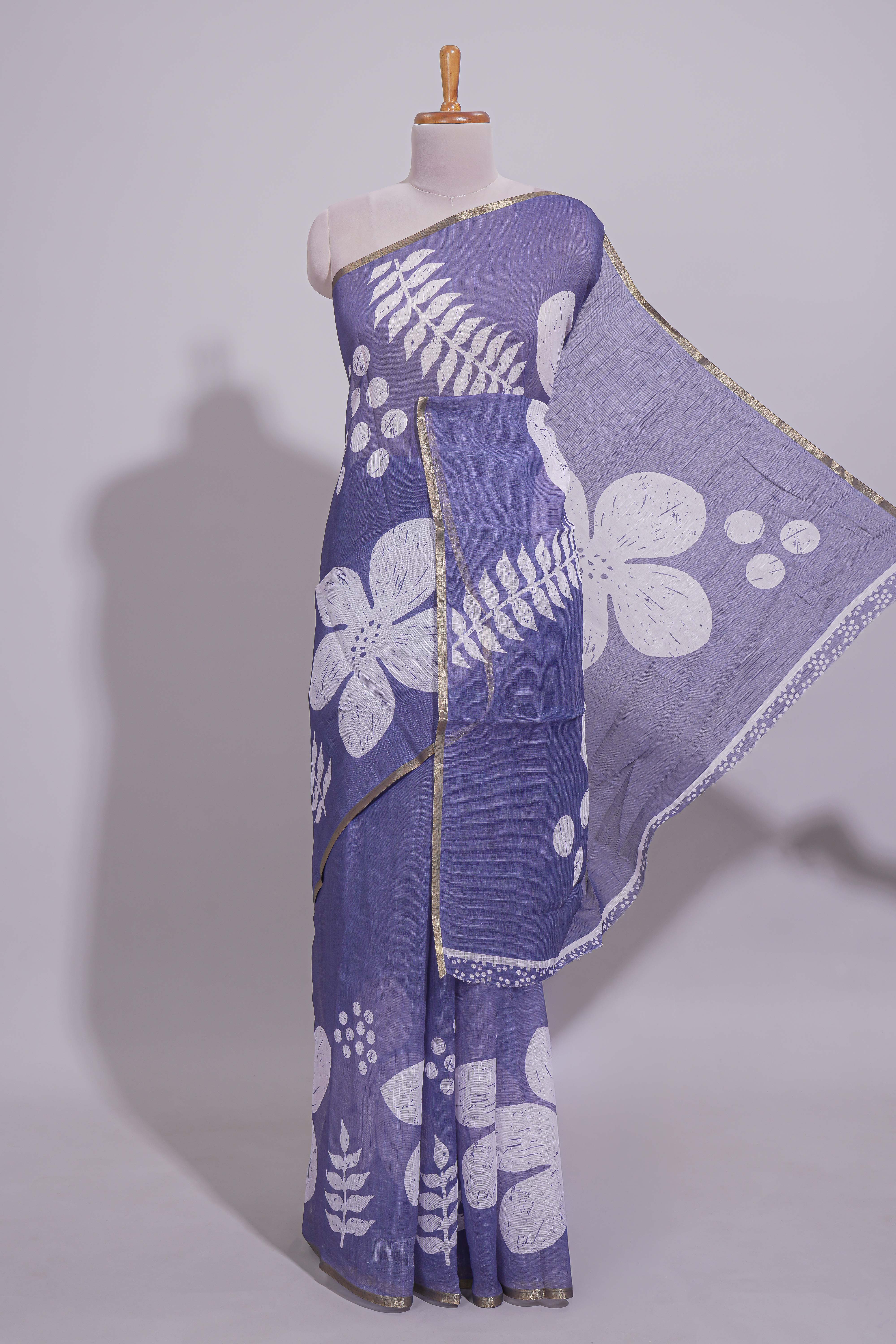Tropical indigo linen saree with bold white floral and geometric prints finished with a subtle metallic border along with matching blouse