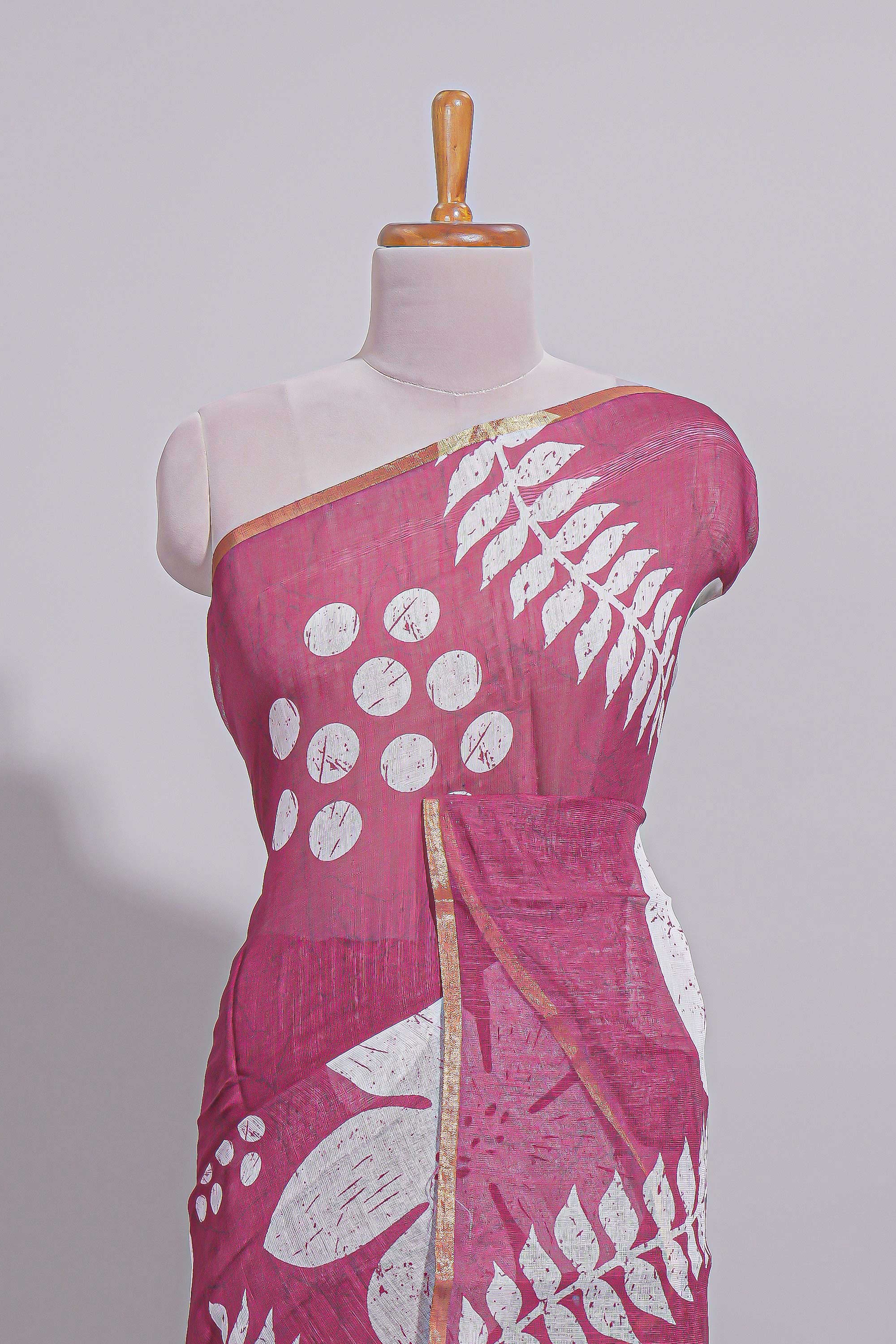 Rani pink linen saree with bold white floral and geometric prints finished with a subtle metallic border along with matching blouse