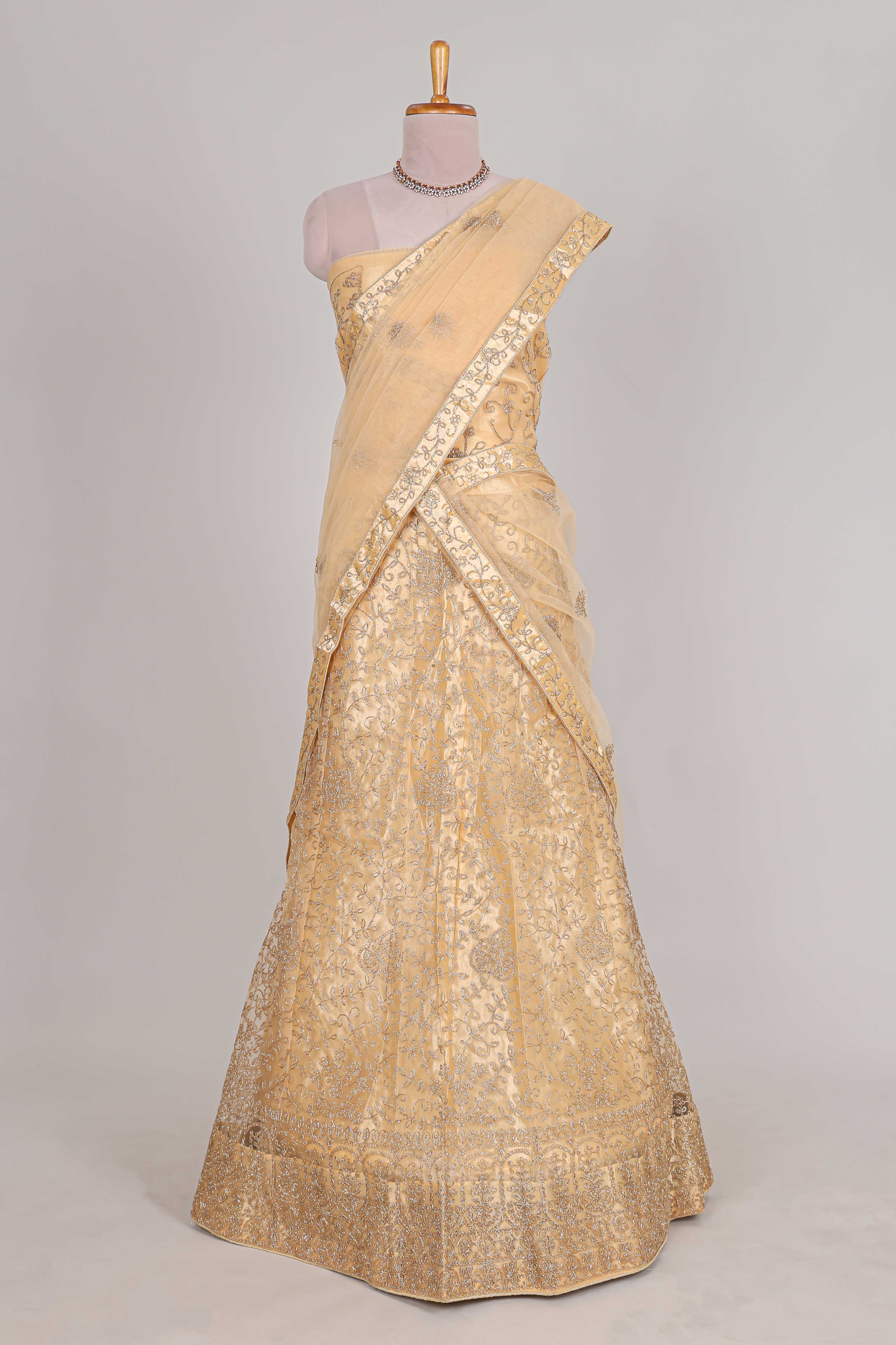 Cream colour net lehenga featuring delicate embroidery with a borderless design paired with a matching self shawl