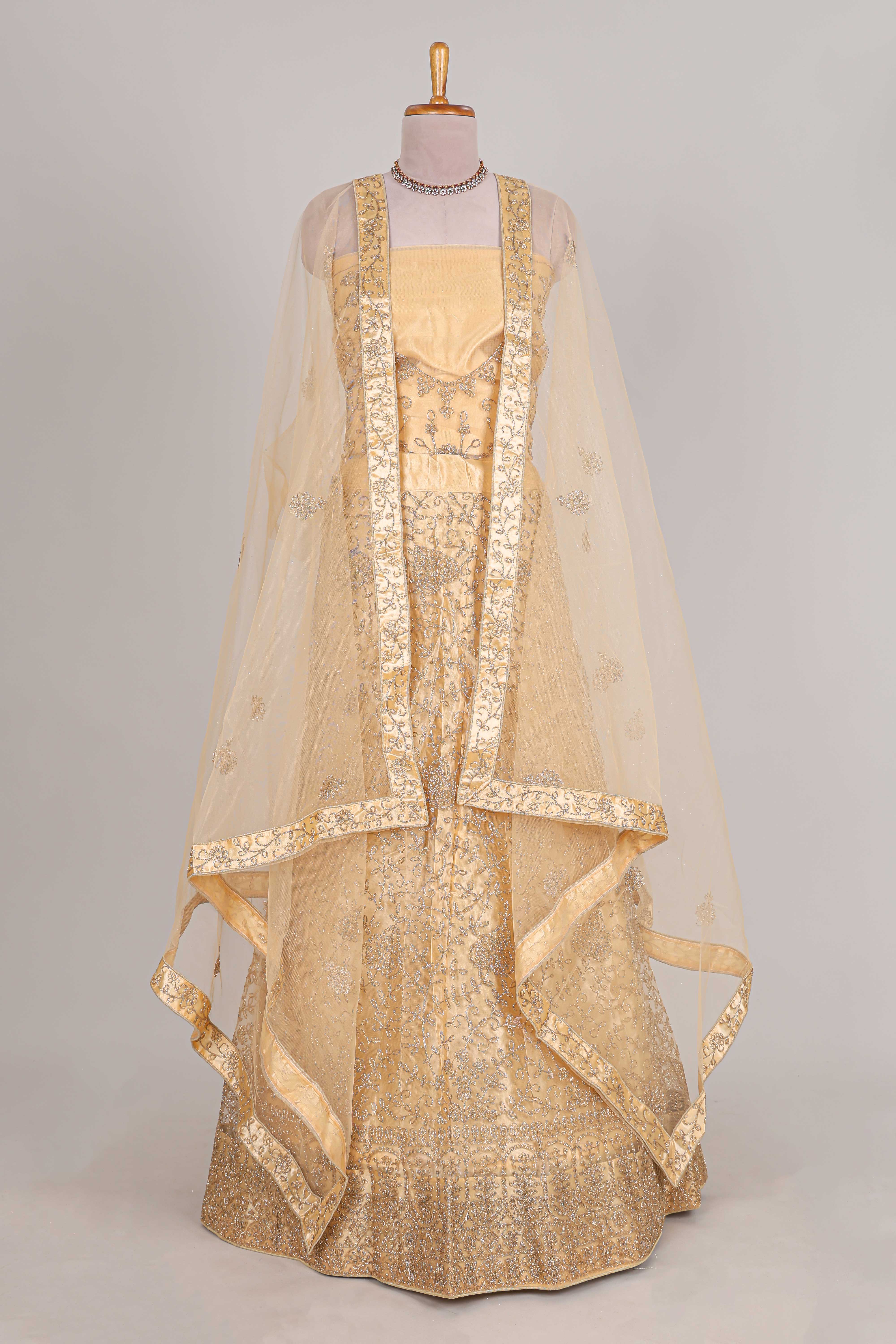 Cream colour net lehenga featuring delicate embroidery with a borderless design paired with a matching self shawl