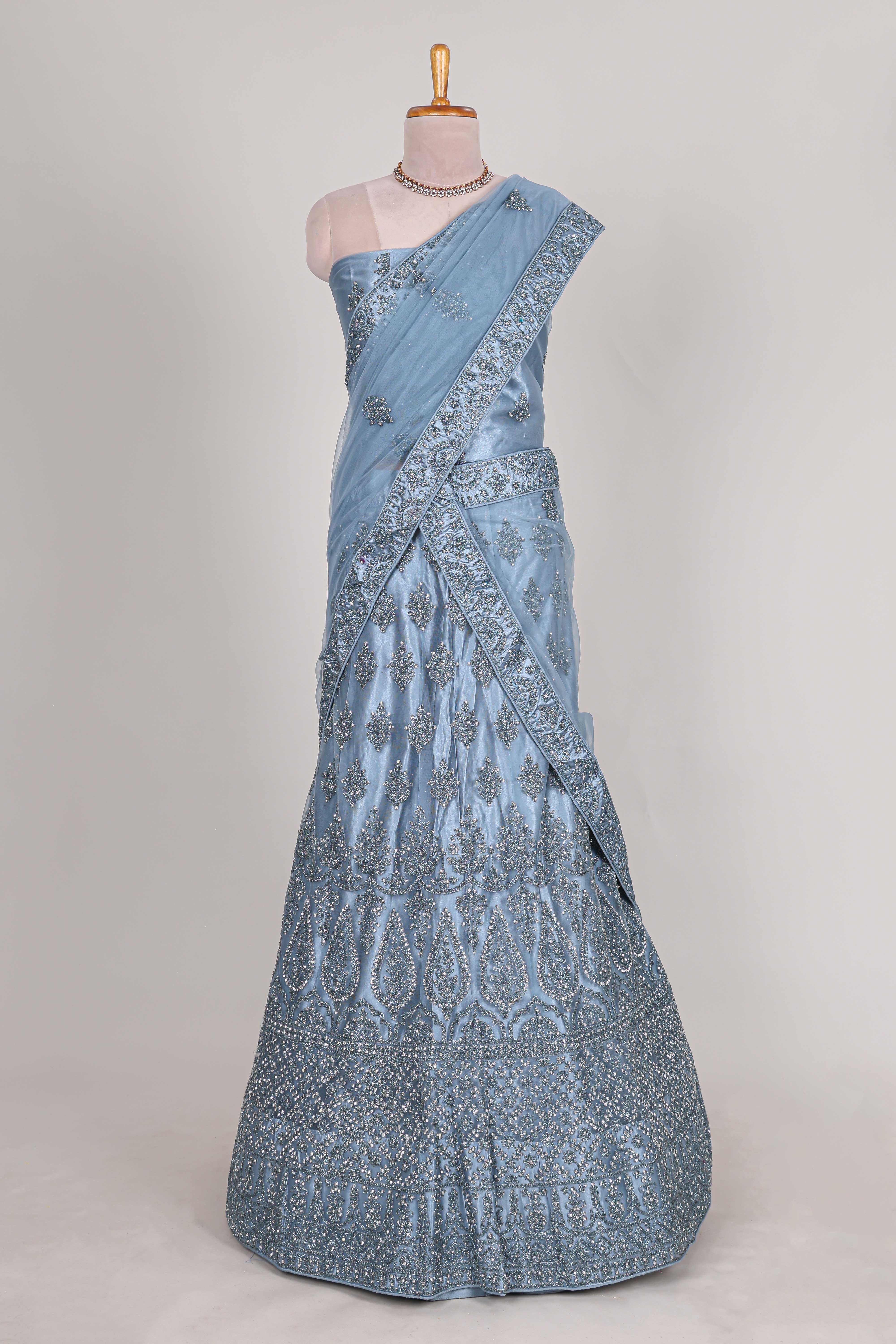 Sea blue colour net lehenga featuring delicate embroidery stone work with a borderless design paired with a matching self shawl