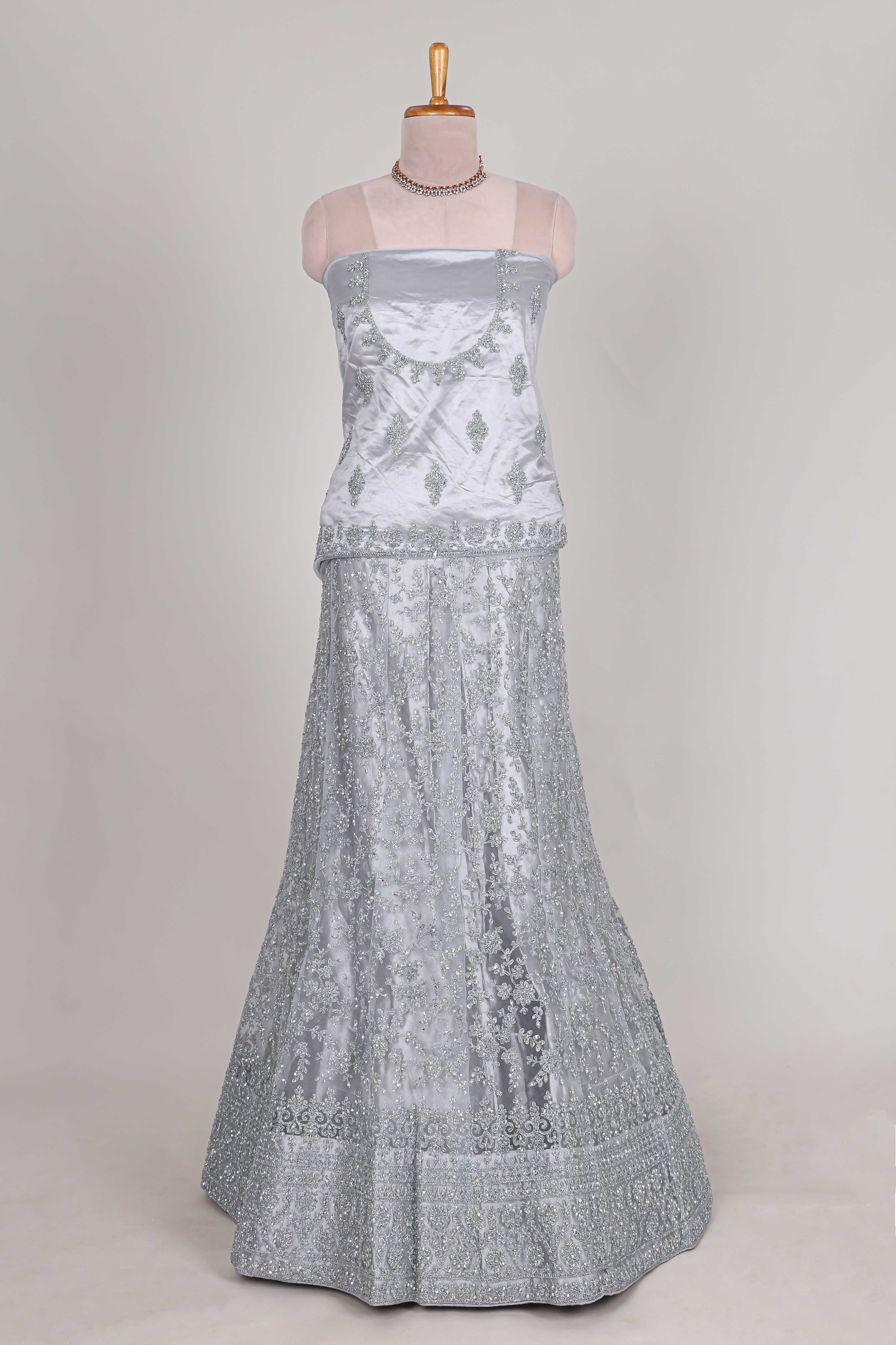 Silver colour net lehenga featuring delicate embroidery stone work with a borderless design paired with a matching self shawl
