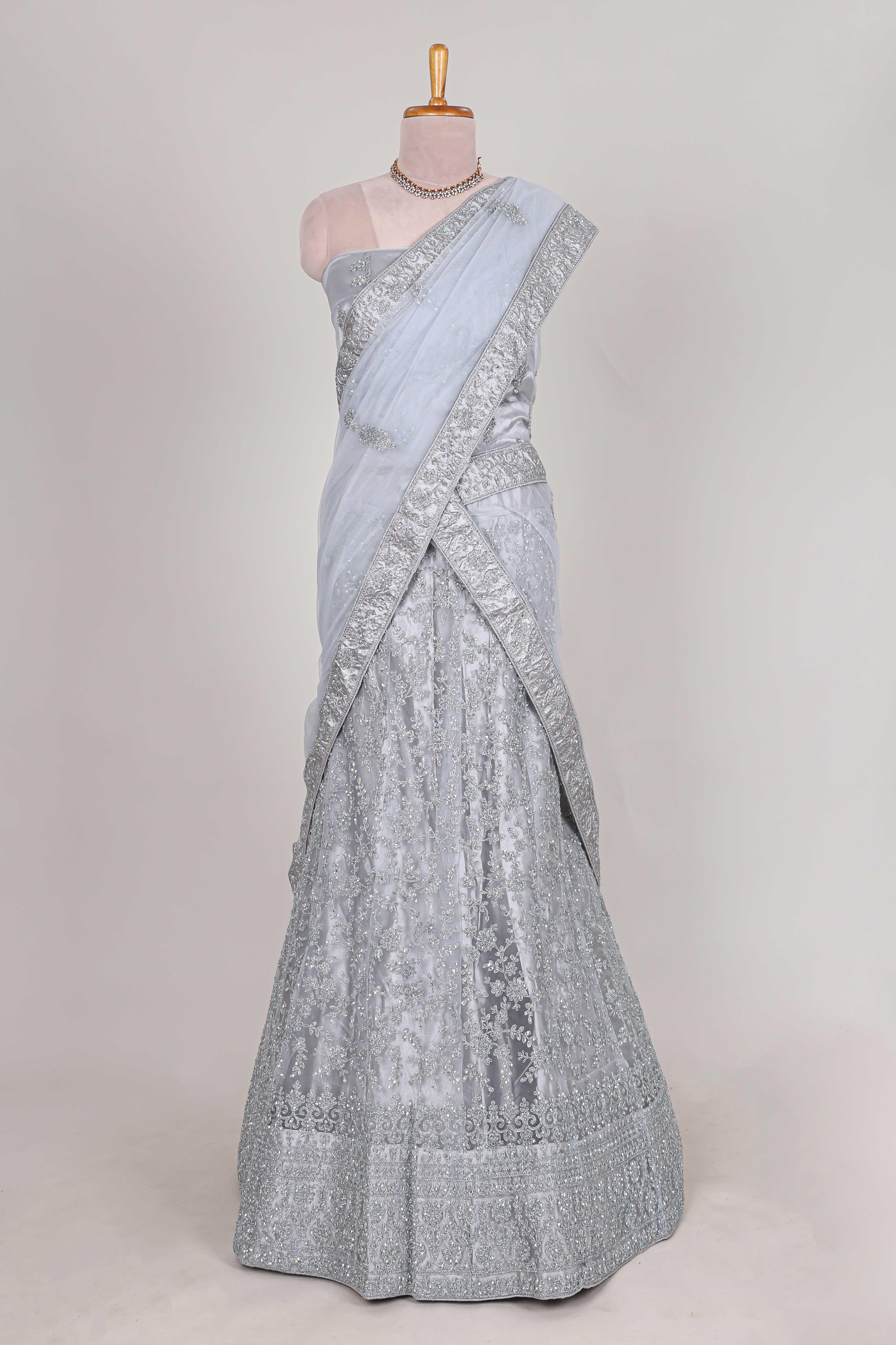 Silver colour net lehenga featuring delicate embroidery stone work with a borderless design paired with a matching self shawl