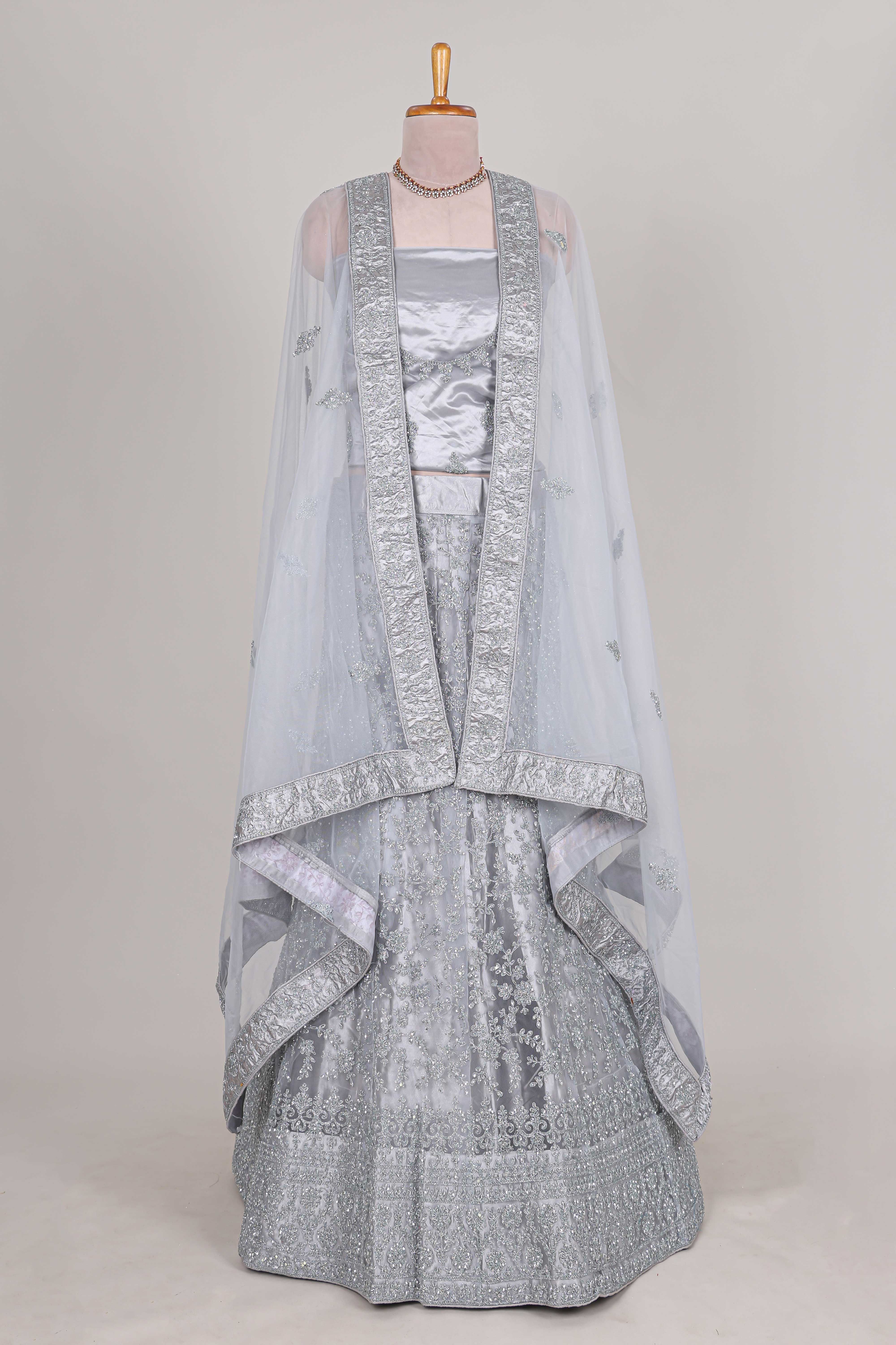 Silver colour net lehenga featuring delicate embroidery stone work with a borderless design paired with a matching self shawl
