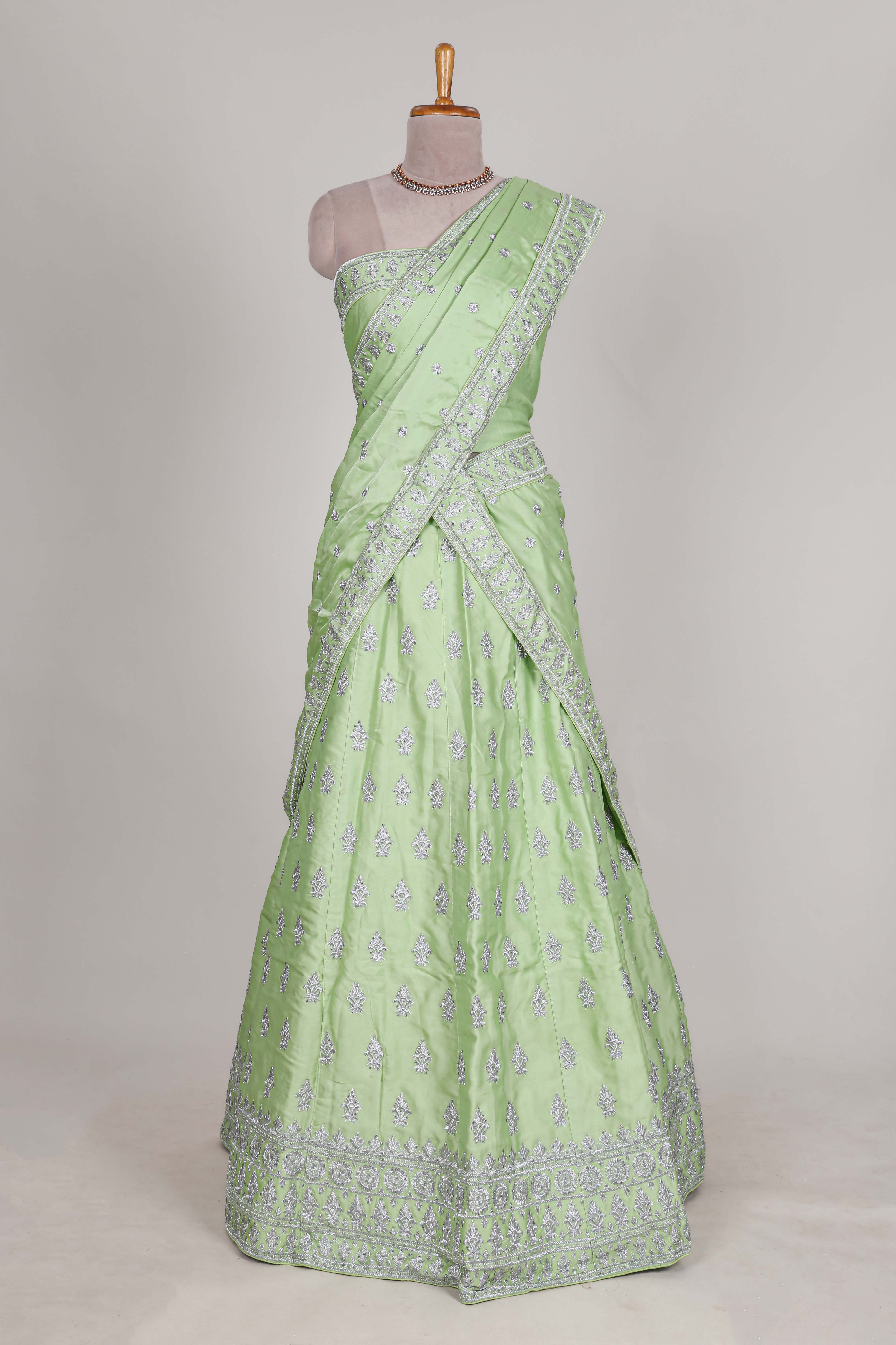 Powder green satin lehenga featuring delicate embroidery with a bordered design paired with a matching self shawl