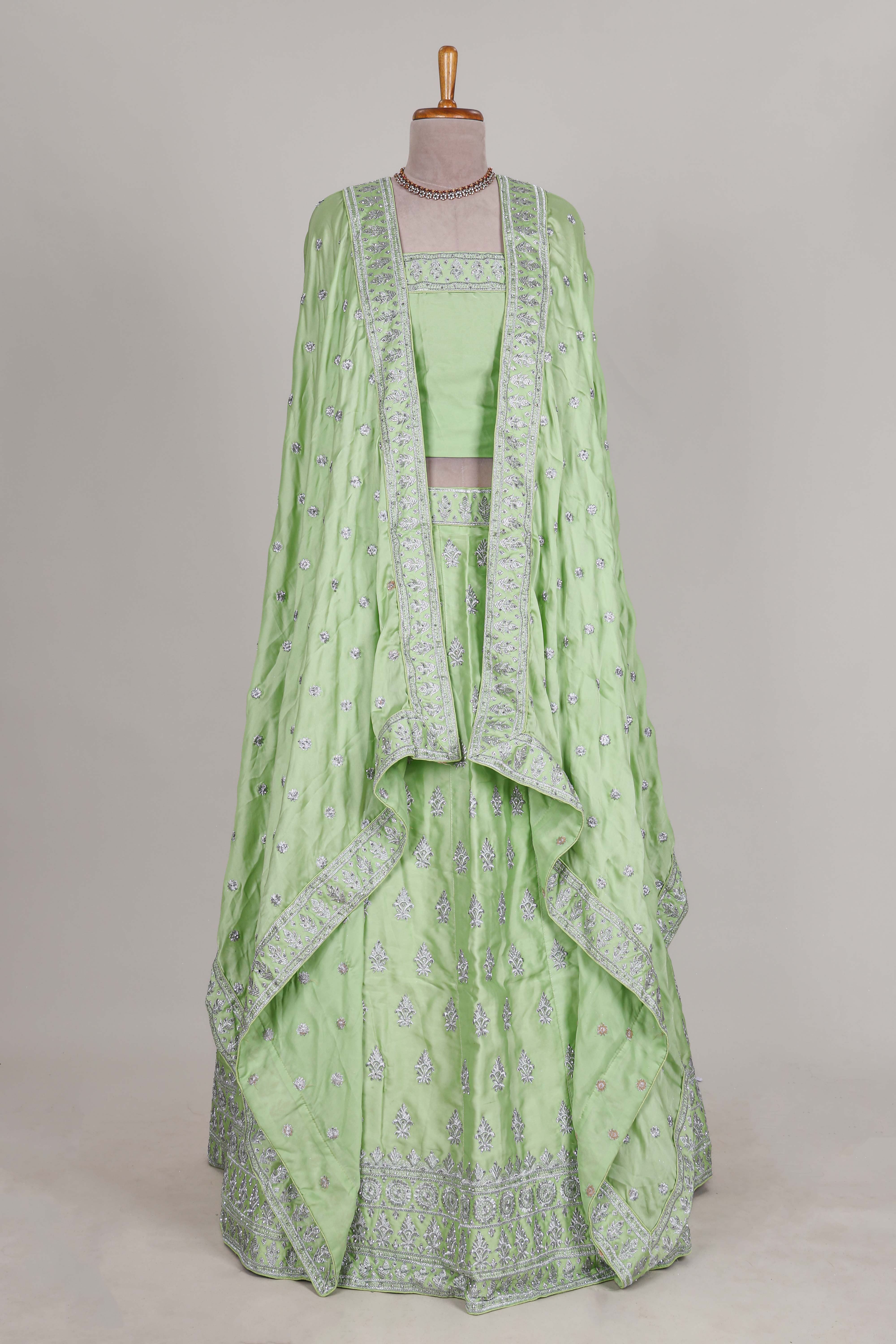 Powder green satin lehenga featuring delicate embroidery with a bordered design paired with a matching self shawl