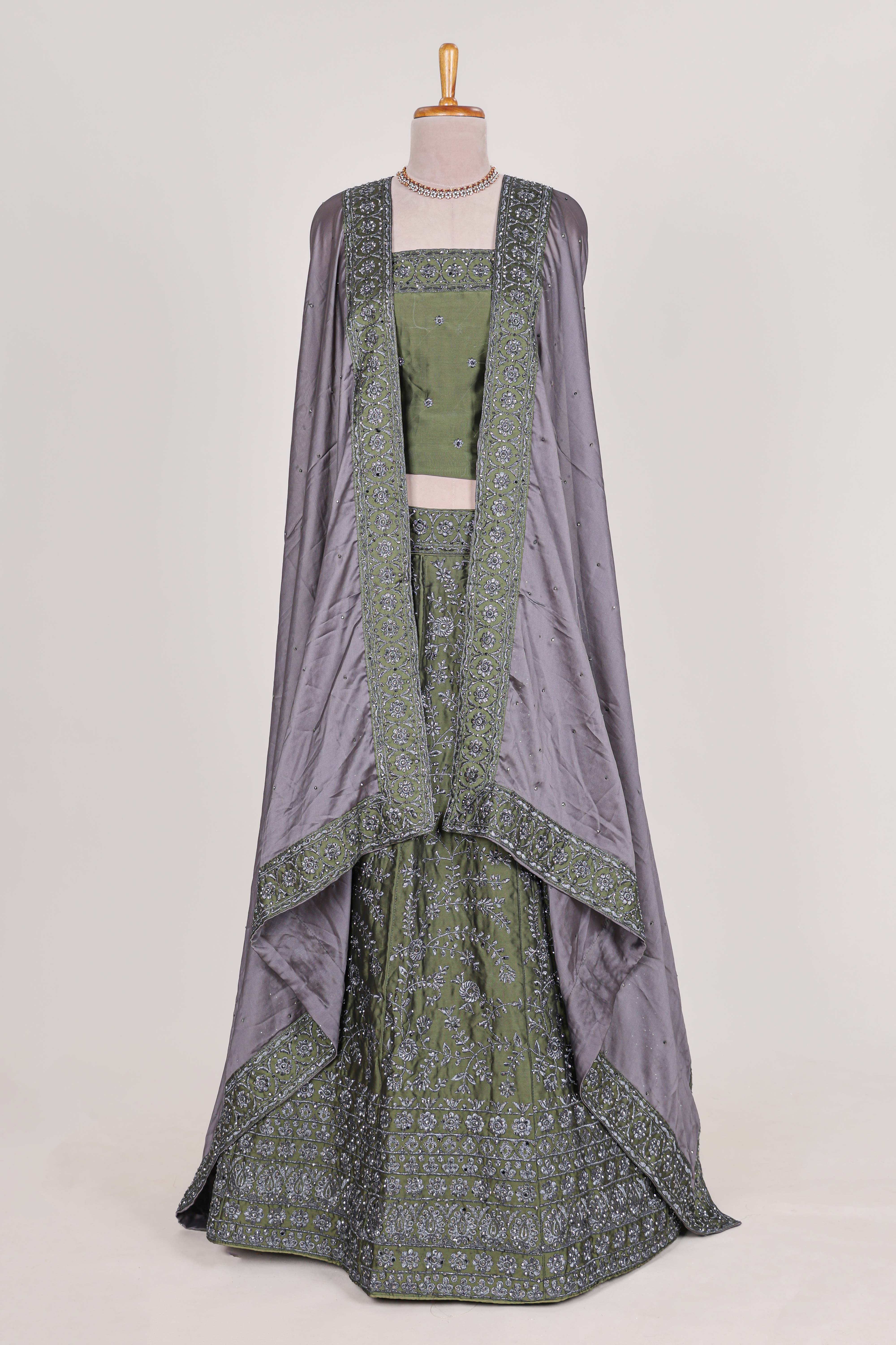 green satin lehenga featuring delicate embroidery with a bordered design paired with contrast shawl