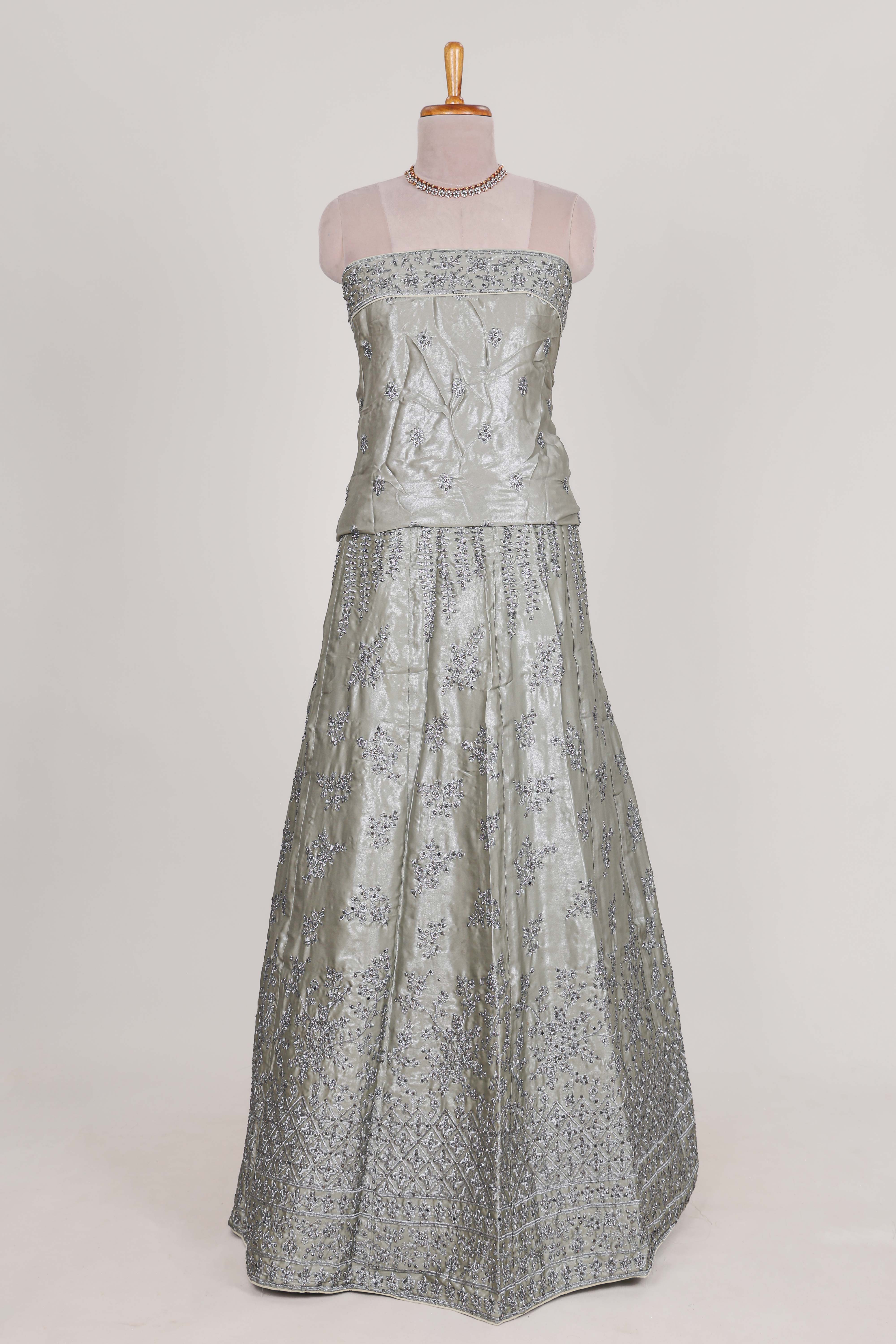 Silver satin lehenga featuring delicate embroidery with a bordered design paired with contrast shawl