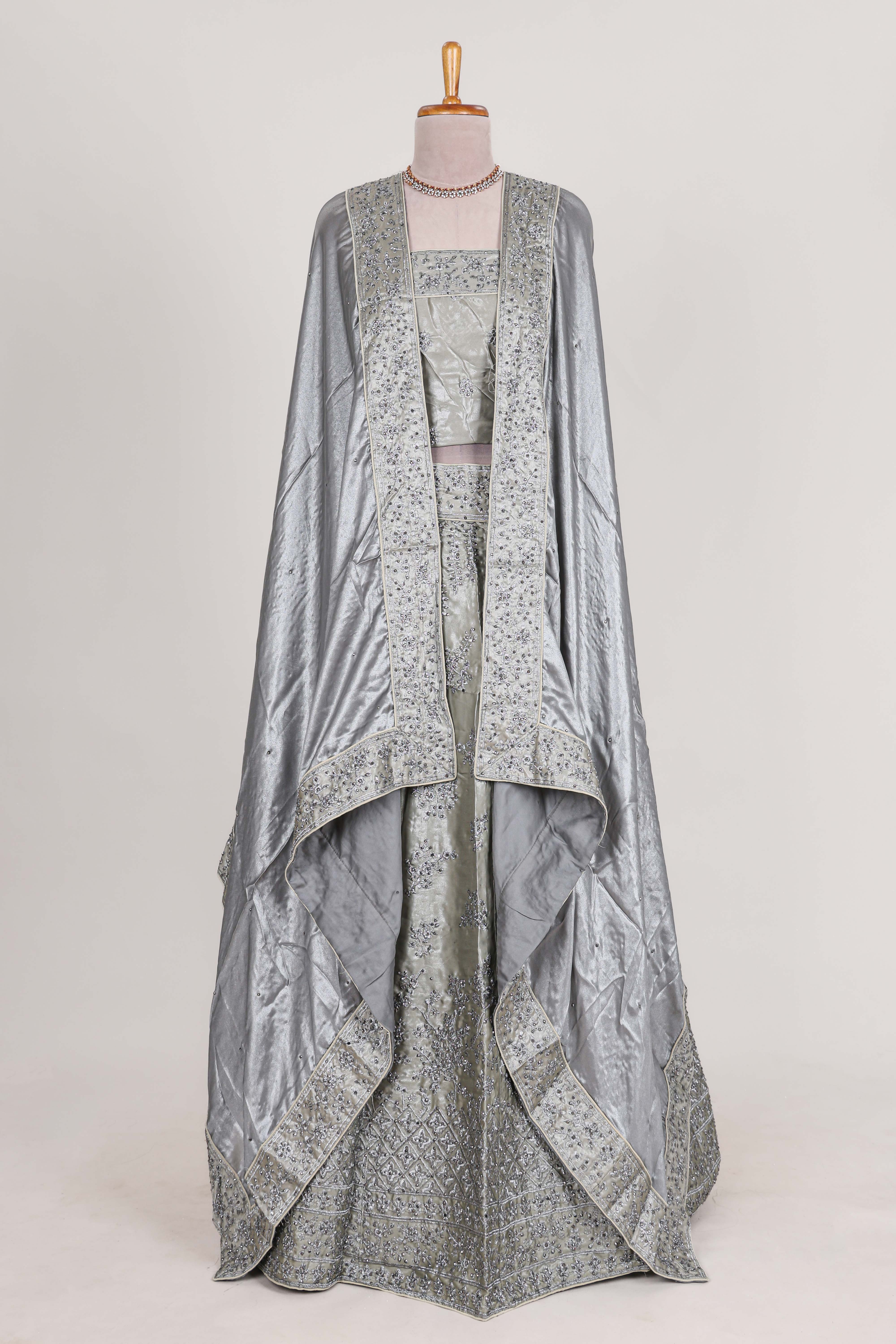 Silver satin lehenga featuring delicate embroidery with a bordered design paired with contrast shawl