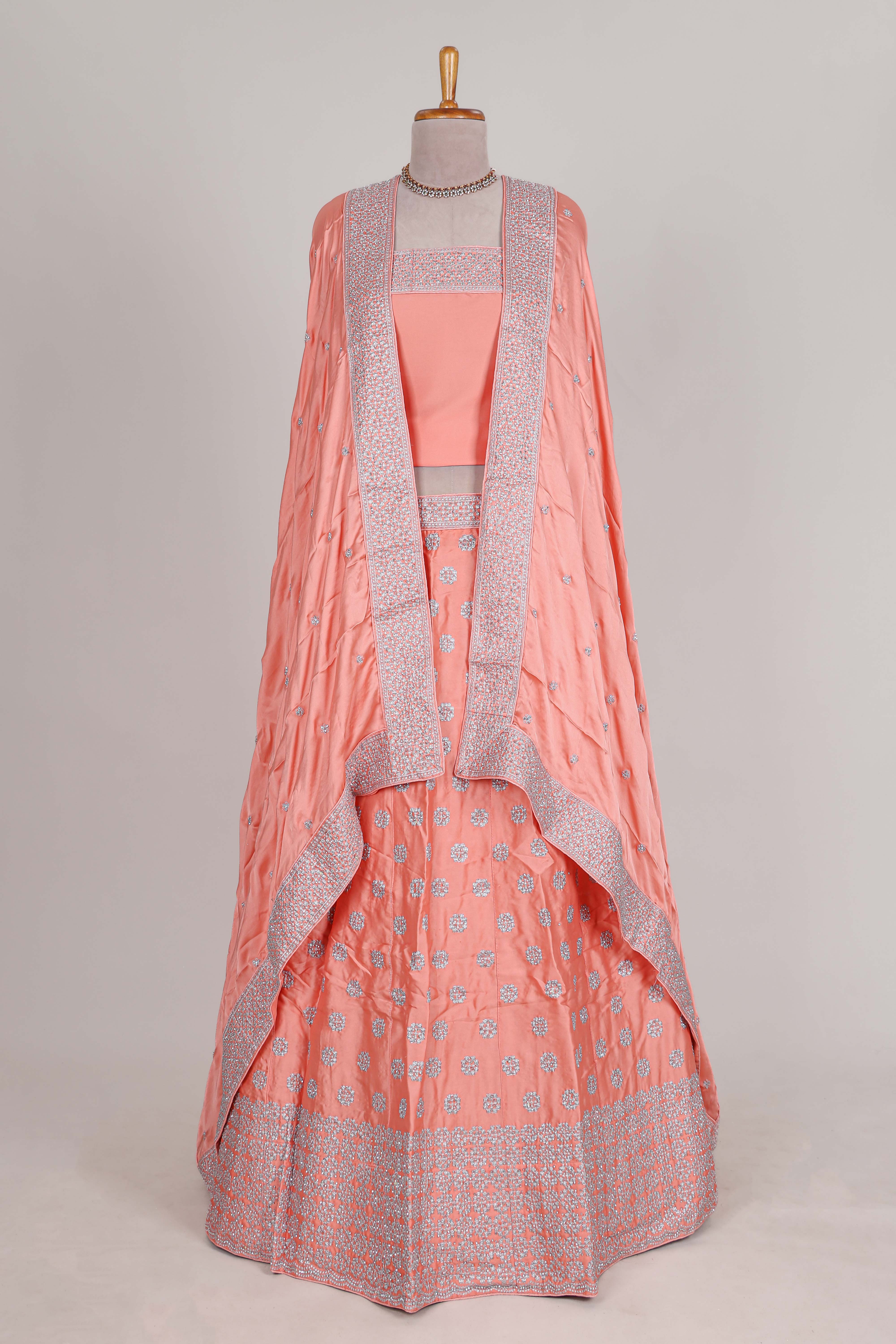 Peach satin lehenga featuring delicate embroidery with a bordered design paired with contrast shawl