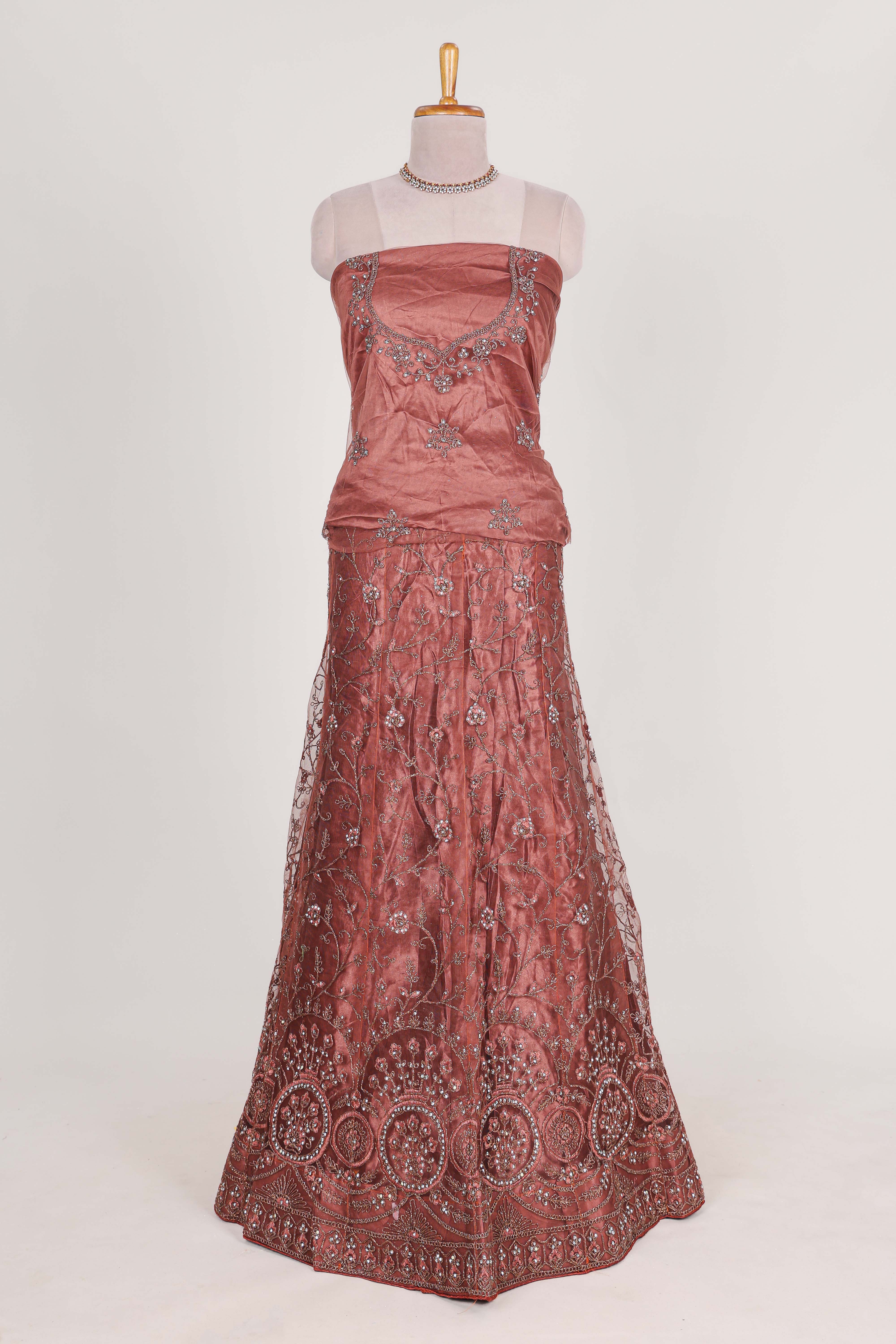 Brown net lehenga intricate embroidery andpaired with a matching embroidered blouse