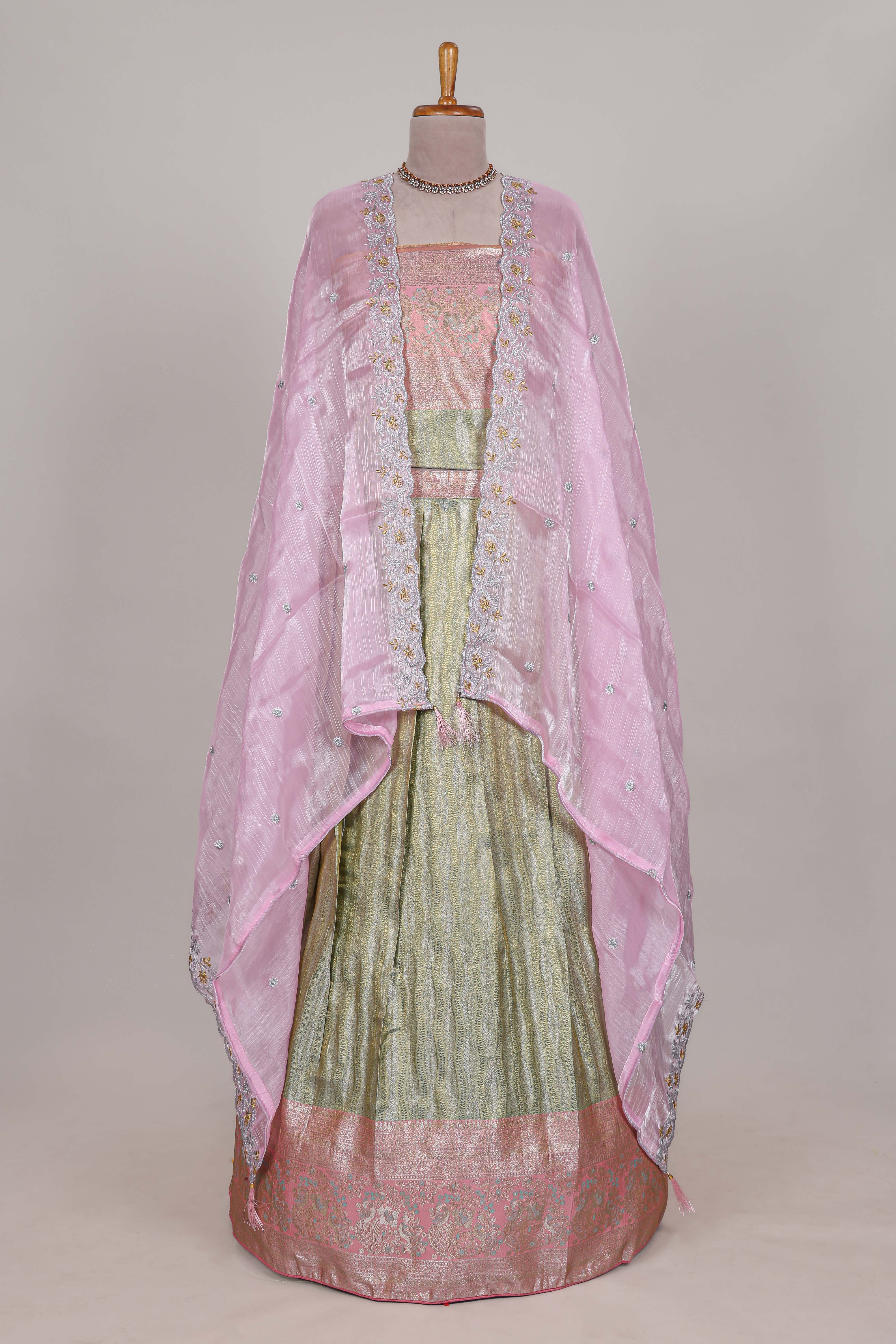 Pastel green tissue lehenga featuring elegant vertical line patterns with a beautiful contrast border Paired with a matching shawl