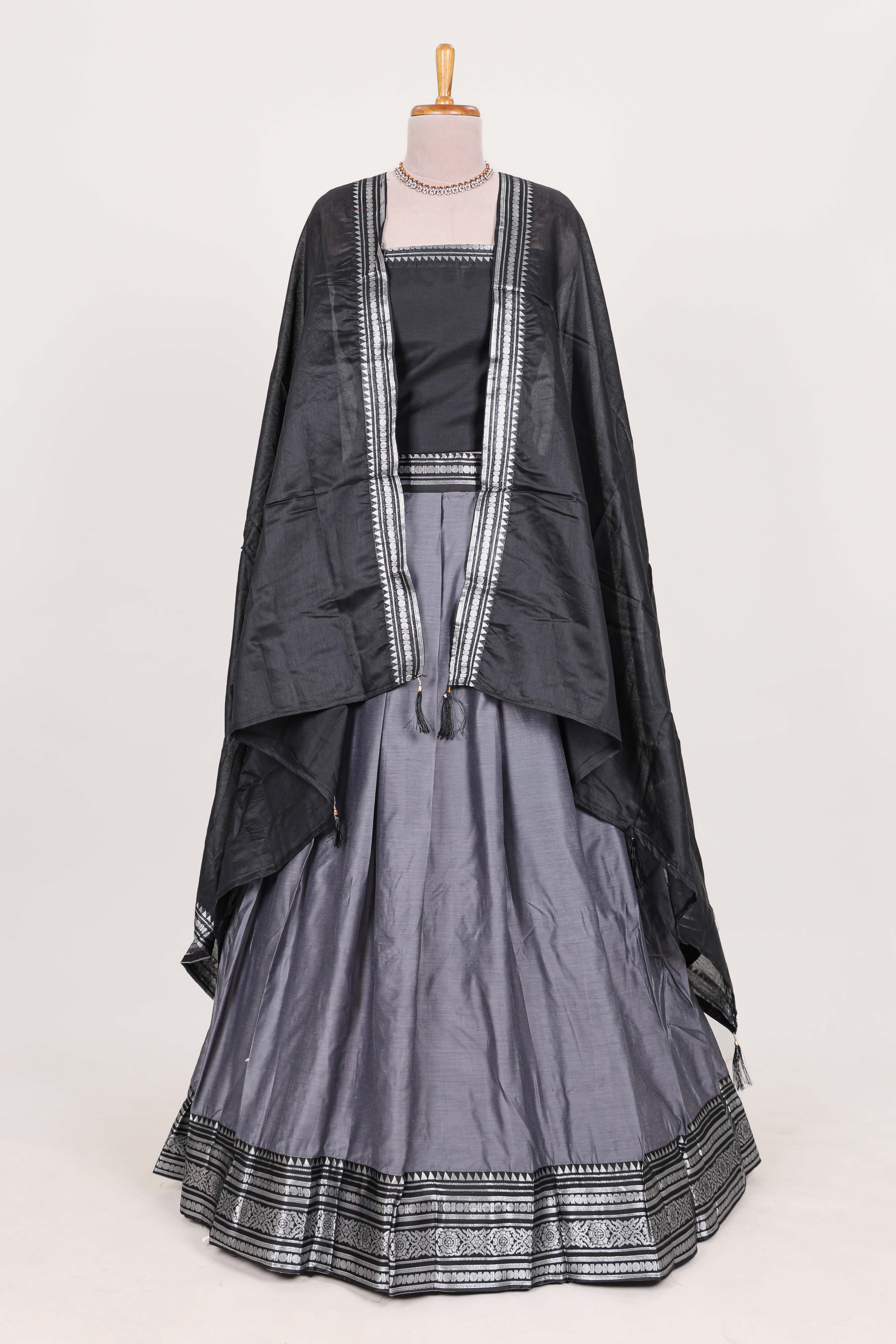 Grey silk cotton lehenga with a black shawl with a traditional silver zari woven border and contrast blouse