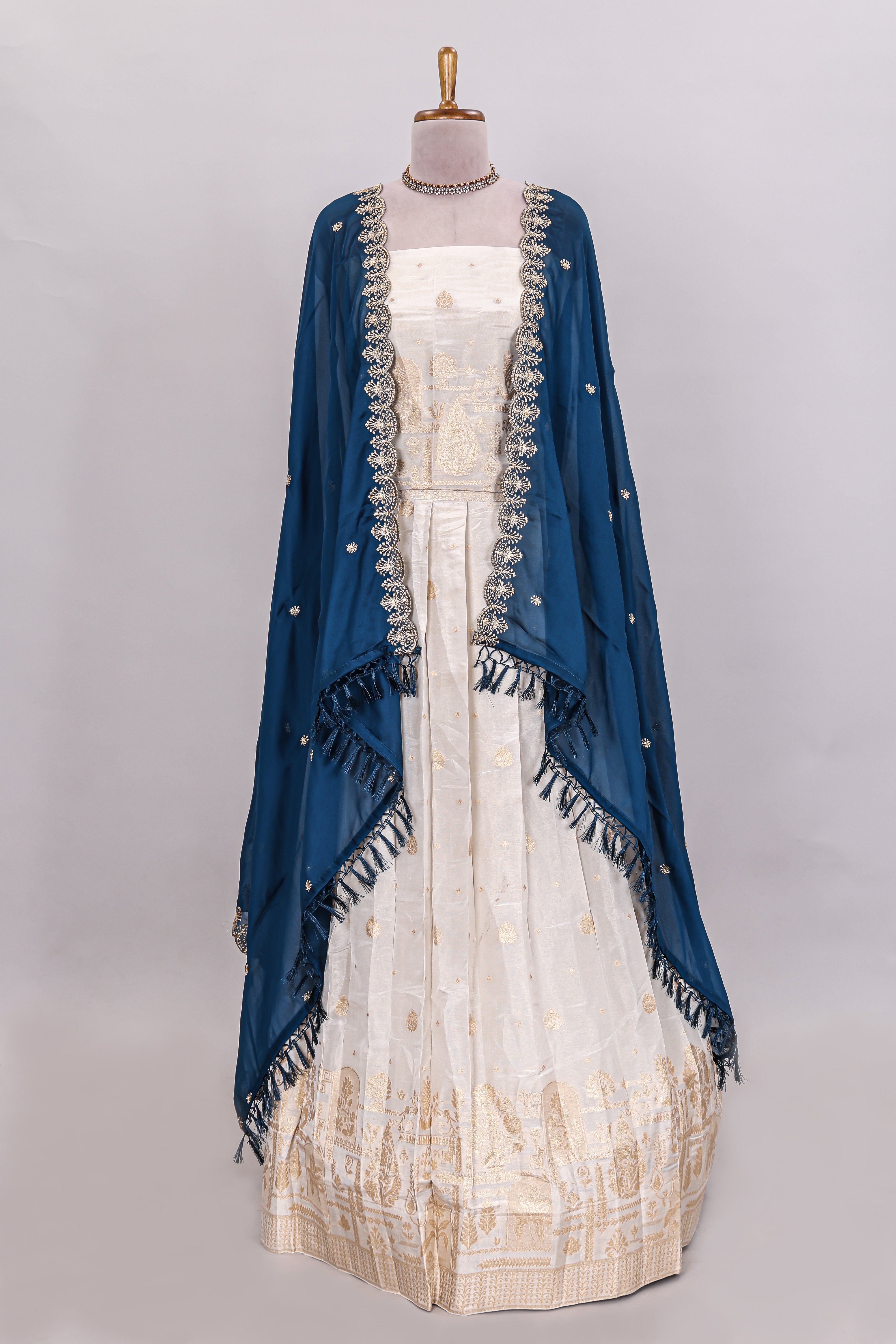 Ivory floral butta motif deigns lehenga featuring self golden zari border and matching blouse Paired with navy blue Floral butta shawl