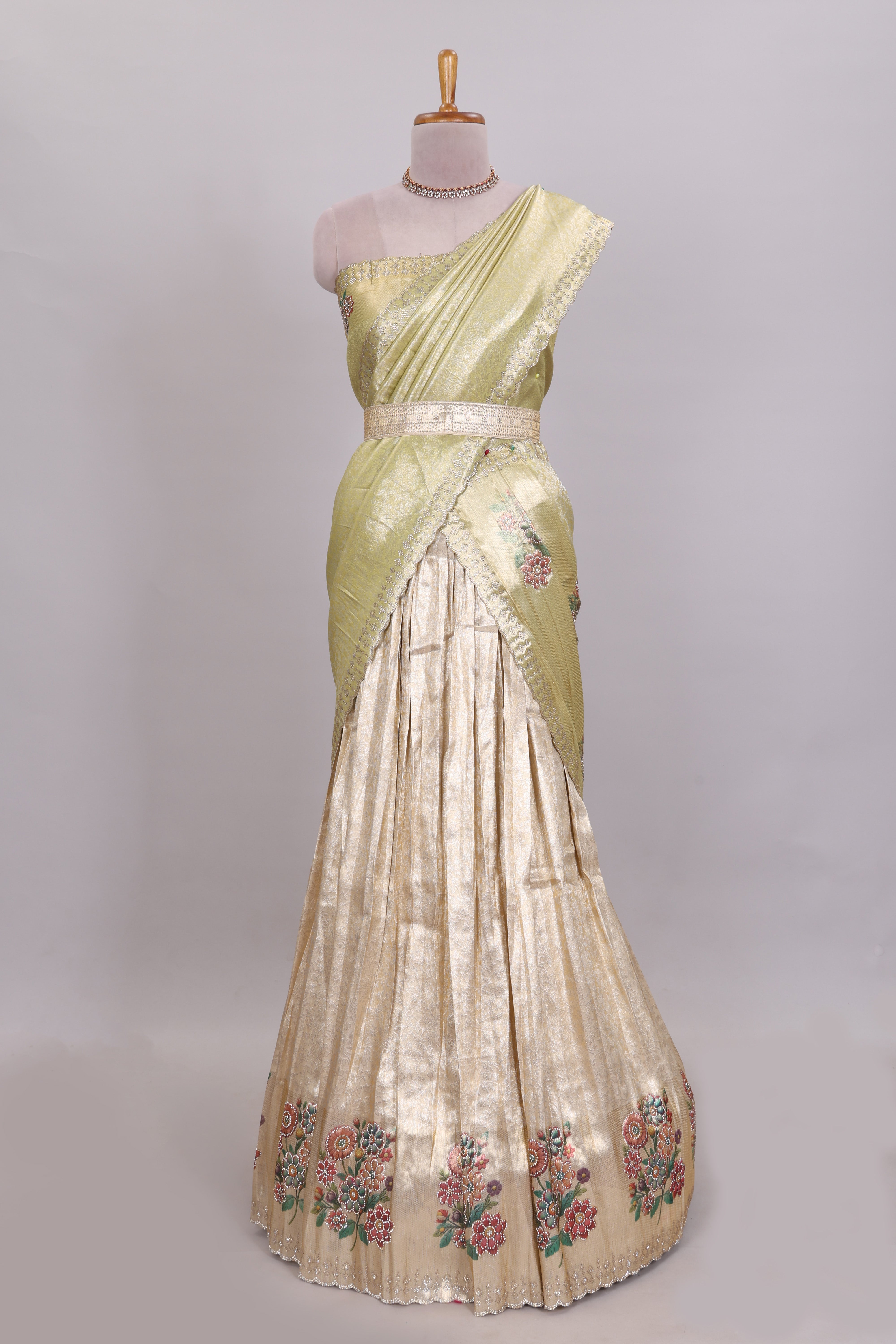 Gold shade zari designed lehanga with self floral motifs border and light green shade contrast blouse paired with plain shawl with few floral motifs