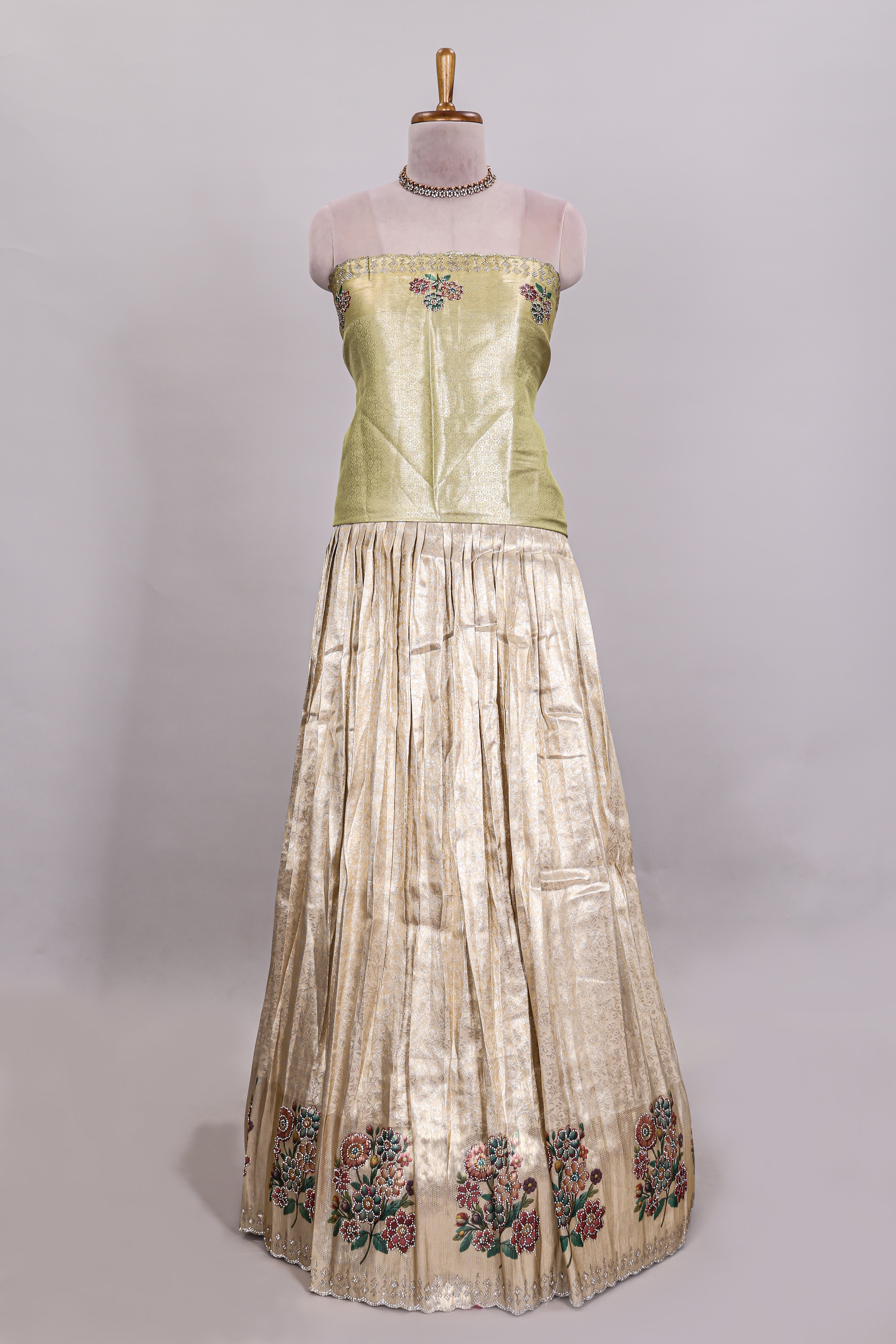 Gold shade zari designed lehanga with self floral motifs border and light green shade contrast blouse paired with plain shawl with few floral motifs