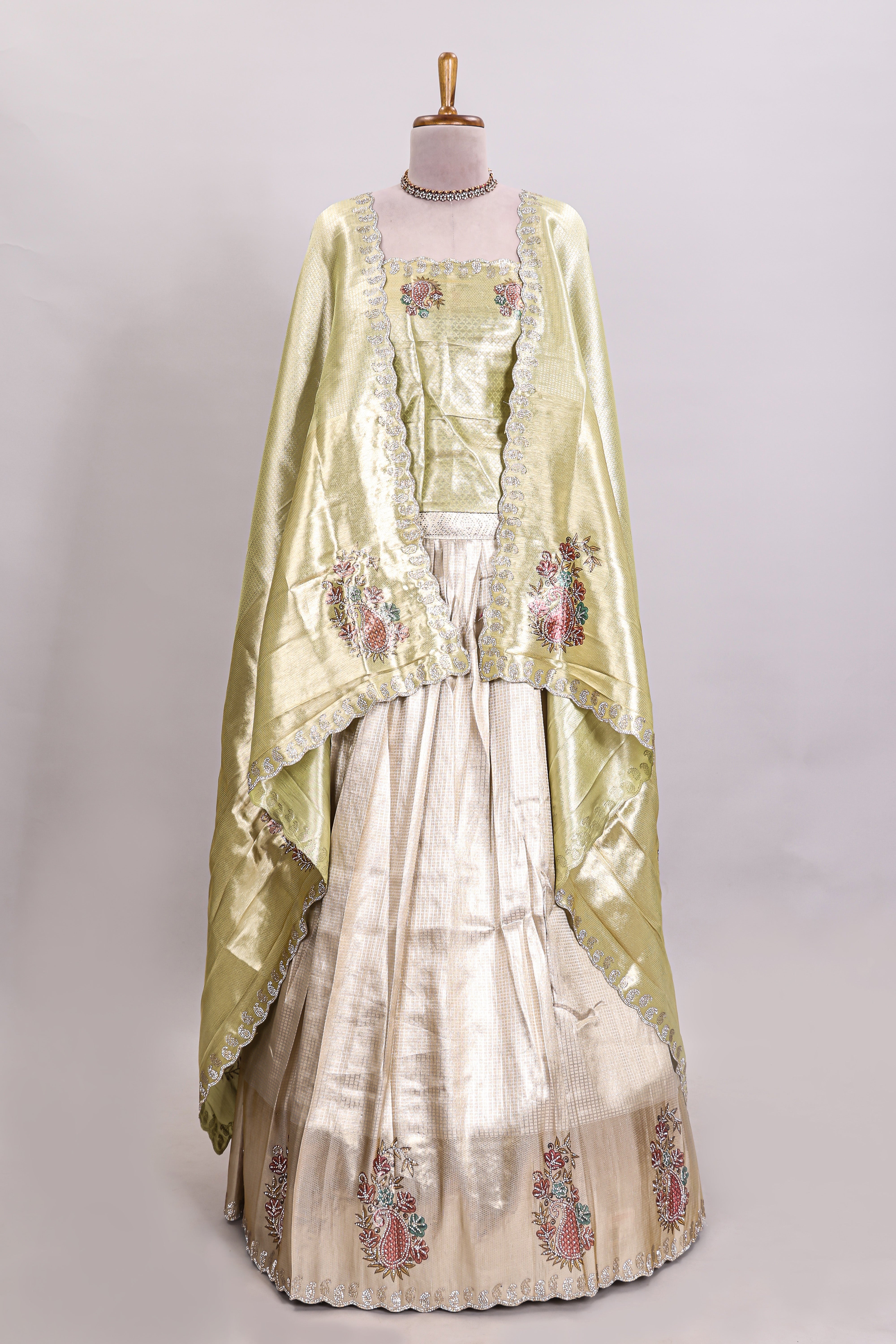Gold shade lehanga with self manga motif border and light green shade contrast blouse paired with plain shawl with floral motifs