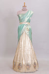 Off white tissue lehenga featuring intricate woven floral paisley motifs with a beautiful zari border Paired with a seafoam green shawl