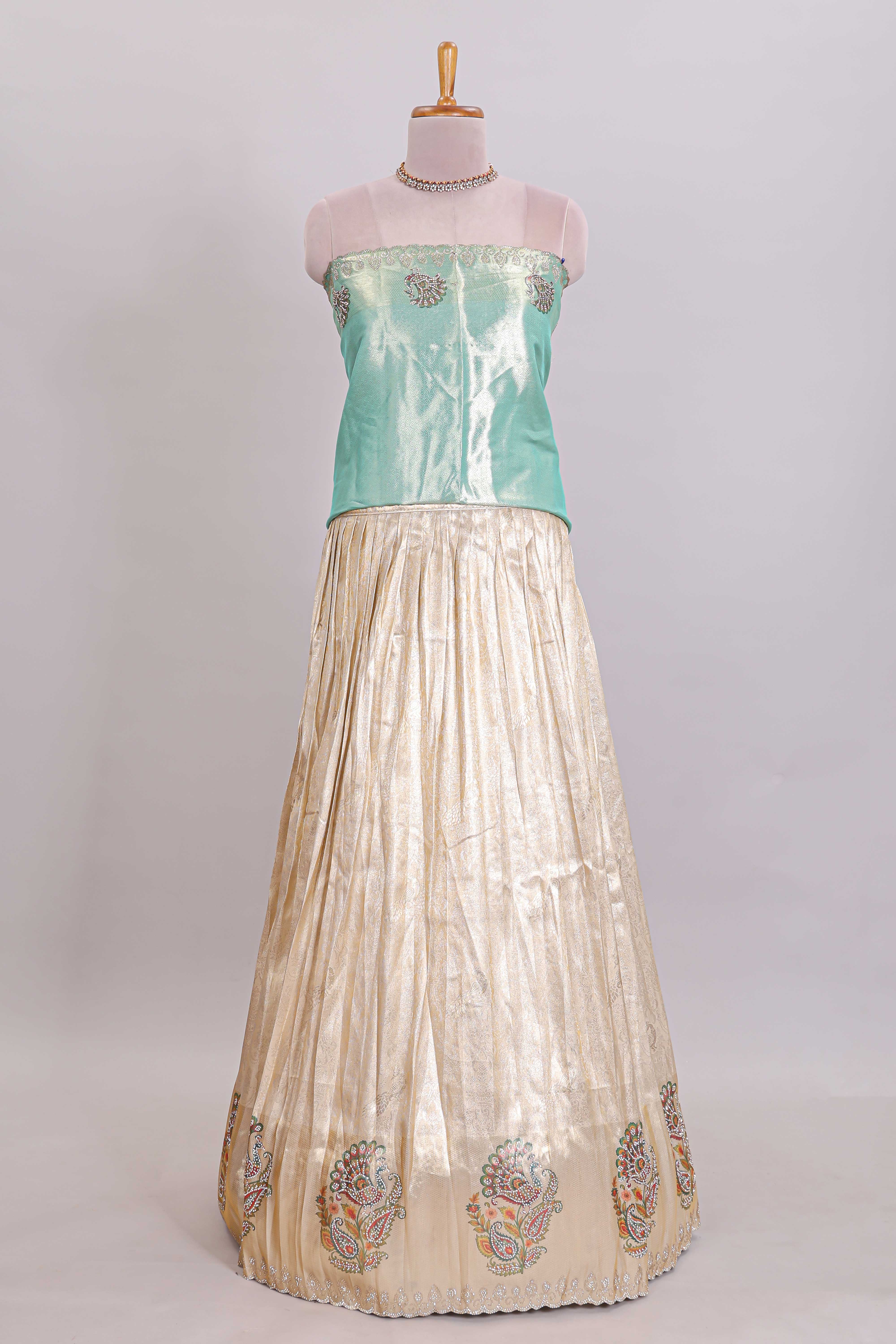 Off white plain lehanga featuring self floral butta design border and contrast teal green blouse beautifully embellished with a stone-work border paired with matching shawl