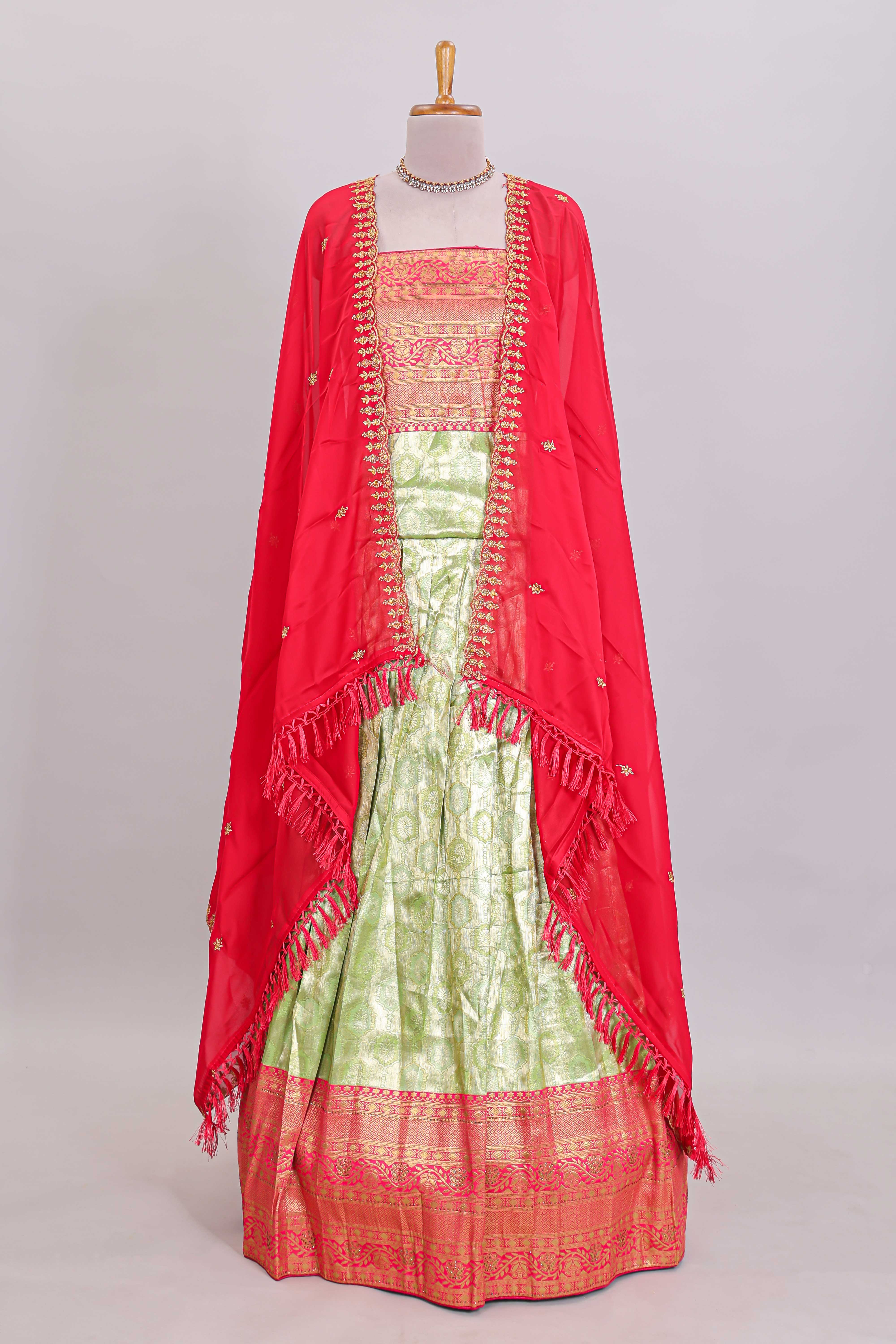 Pastel green Manga Butta motifs lehanga featuring contrasting border and matching blouse paired with contrast red shawl