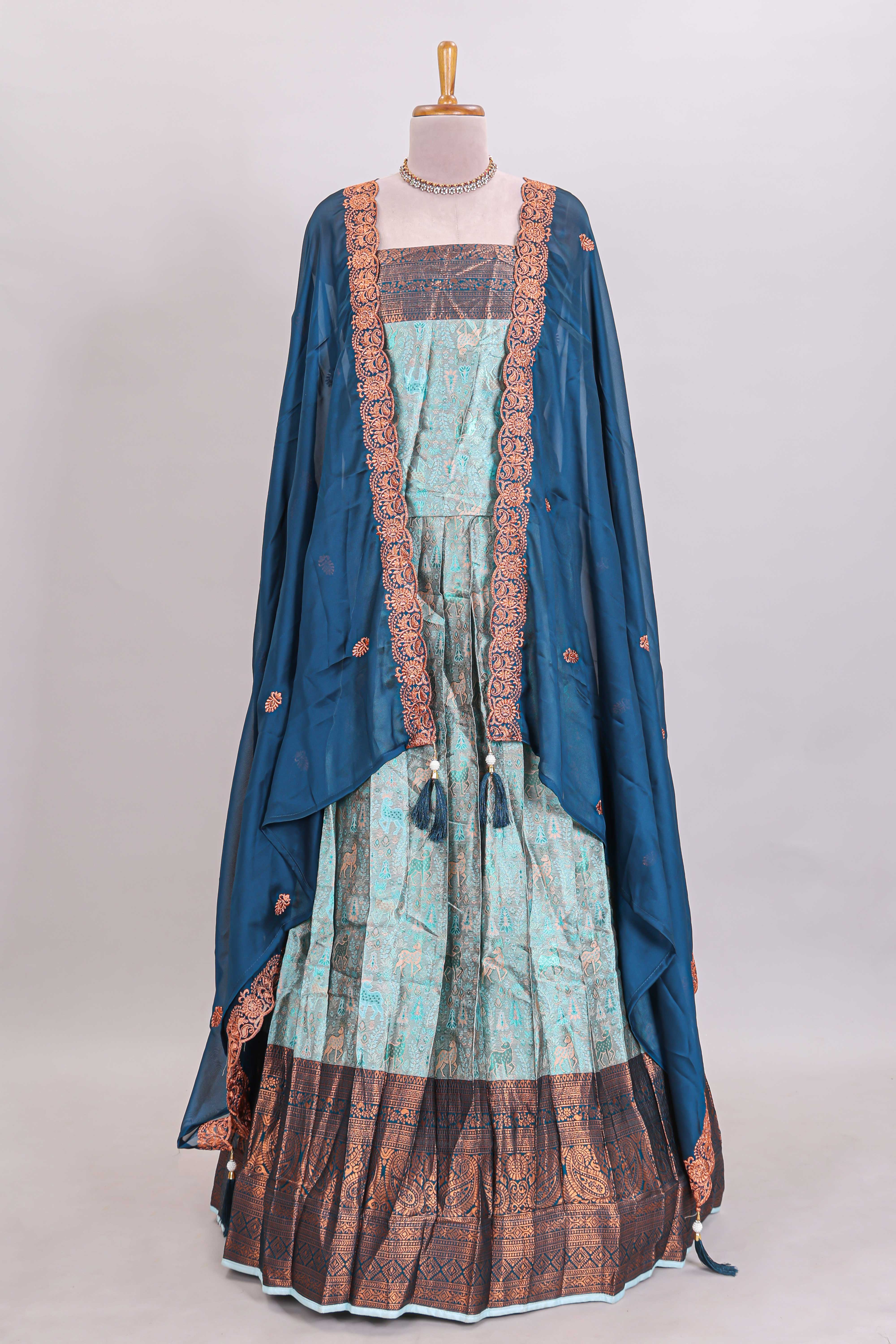 Light aqua blue floral and deer motifs lehanga featuring contrasting geometric zari border and matching blouse paired with contrast blue shawl