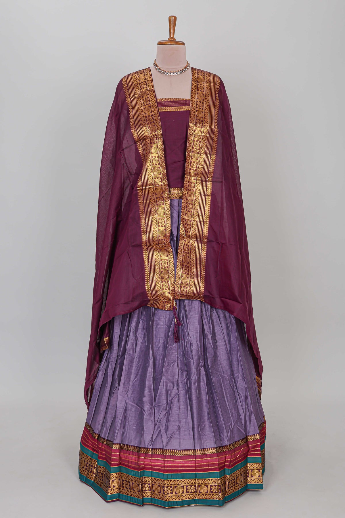 Lavender shade plain lehanga featuring contrasting zari border and blouse paired withmaroonshawl