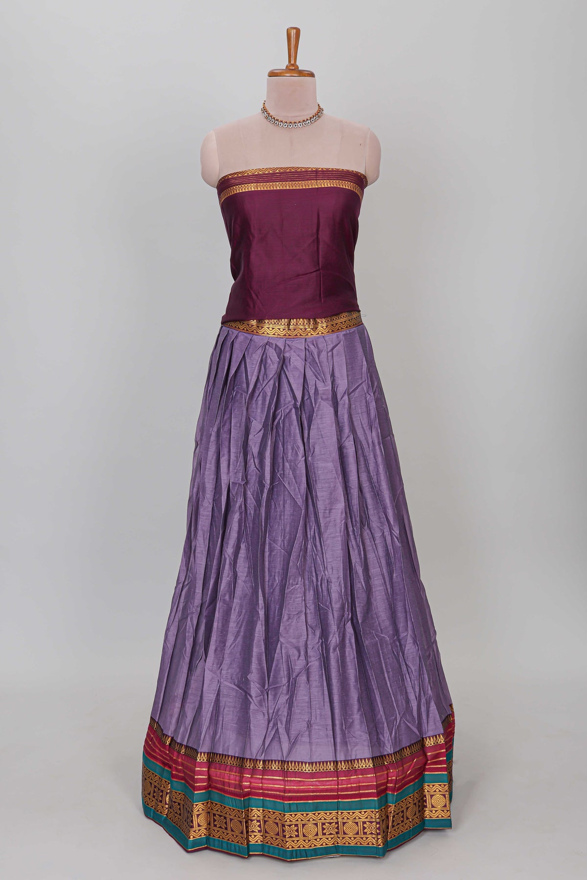 Lavender shade plain lehanga featuring contrasting zari border and blouse paired withmaroonshawl