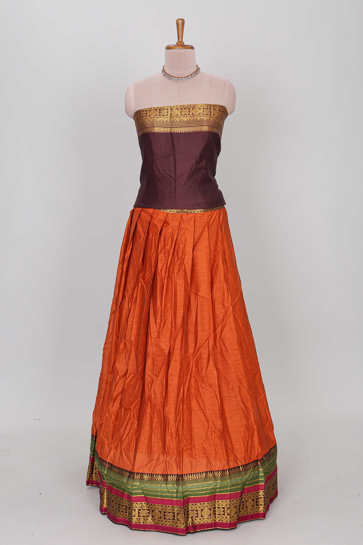 Orange shade plain lehanga featuring contrasting zari border and blouse paired with brown shawl