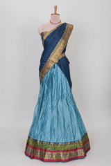 Light blue shade plain lehanga featuring contrasting zari border and blouse paired with dark blue shawl