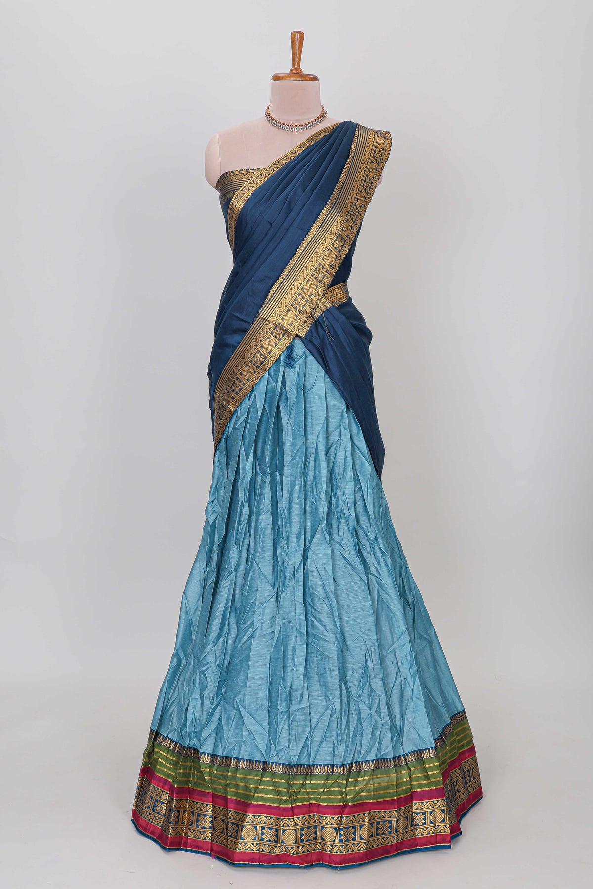 Light blue shade plain lehanga featuring contrasting zari border and blouse paired with dark blue shawl