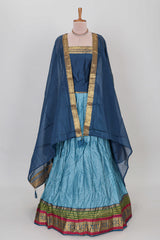Light blue shade plain lehanga featuring contrasting zari border and blouse paired with dark blue shawl