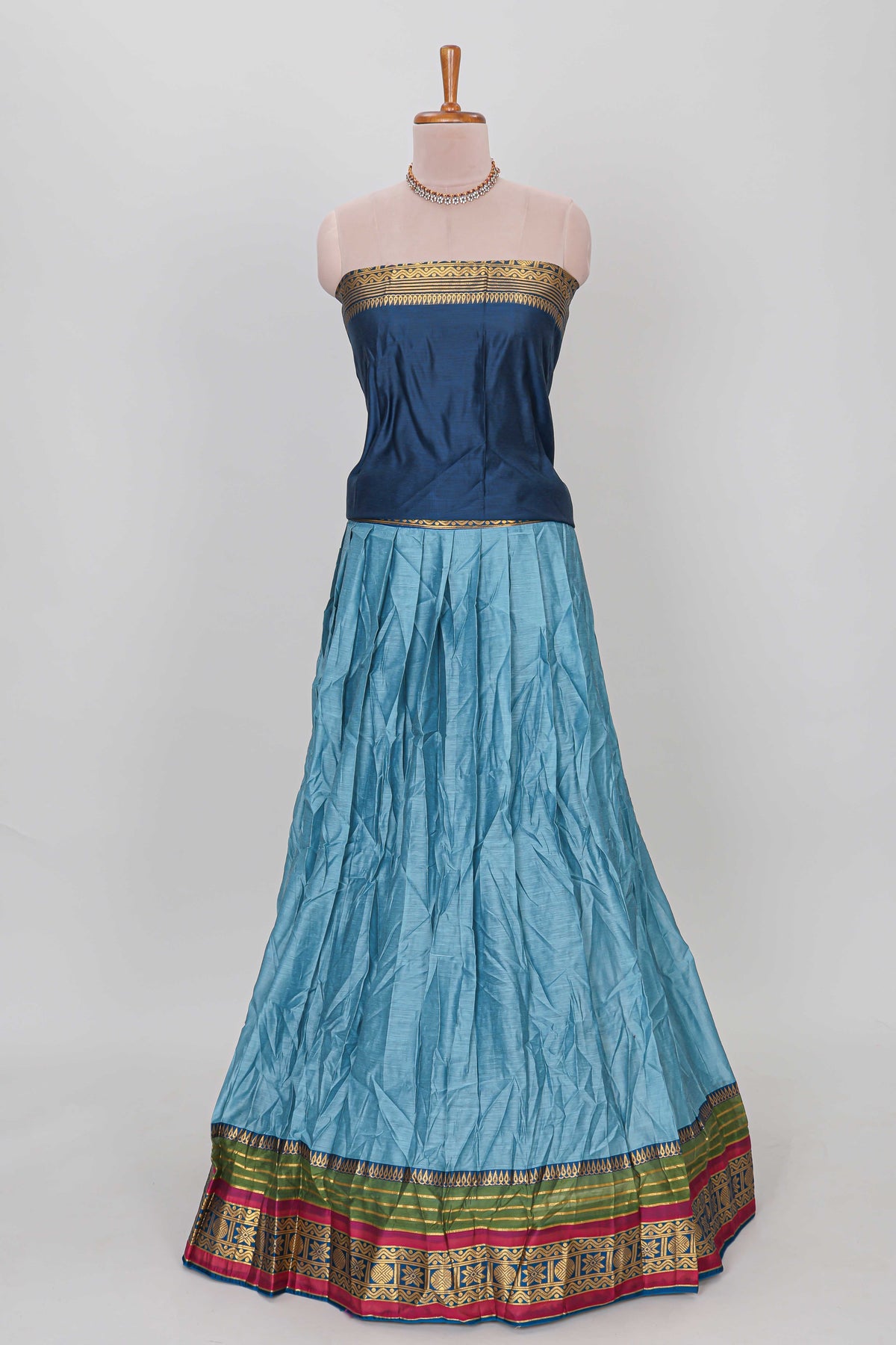Light blue shade plain lehanga featuring contrasting zari border and blouse paired with dark blue shawl