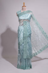 Pastel blue organza saree featuring delicate floral embroidery, intricate lace detailing on the border and pallu with a scalloped finishing along with matching blouse