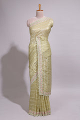 Pastel yellow organza saree featuring delicate floral embroidery intricate lace detailing on the border and pallu with a scalloped finishing along with matching blouse
