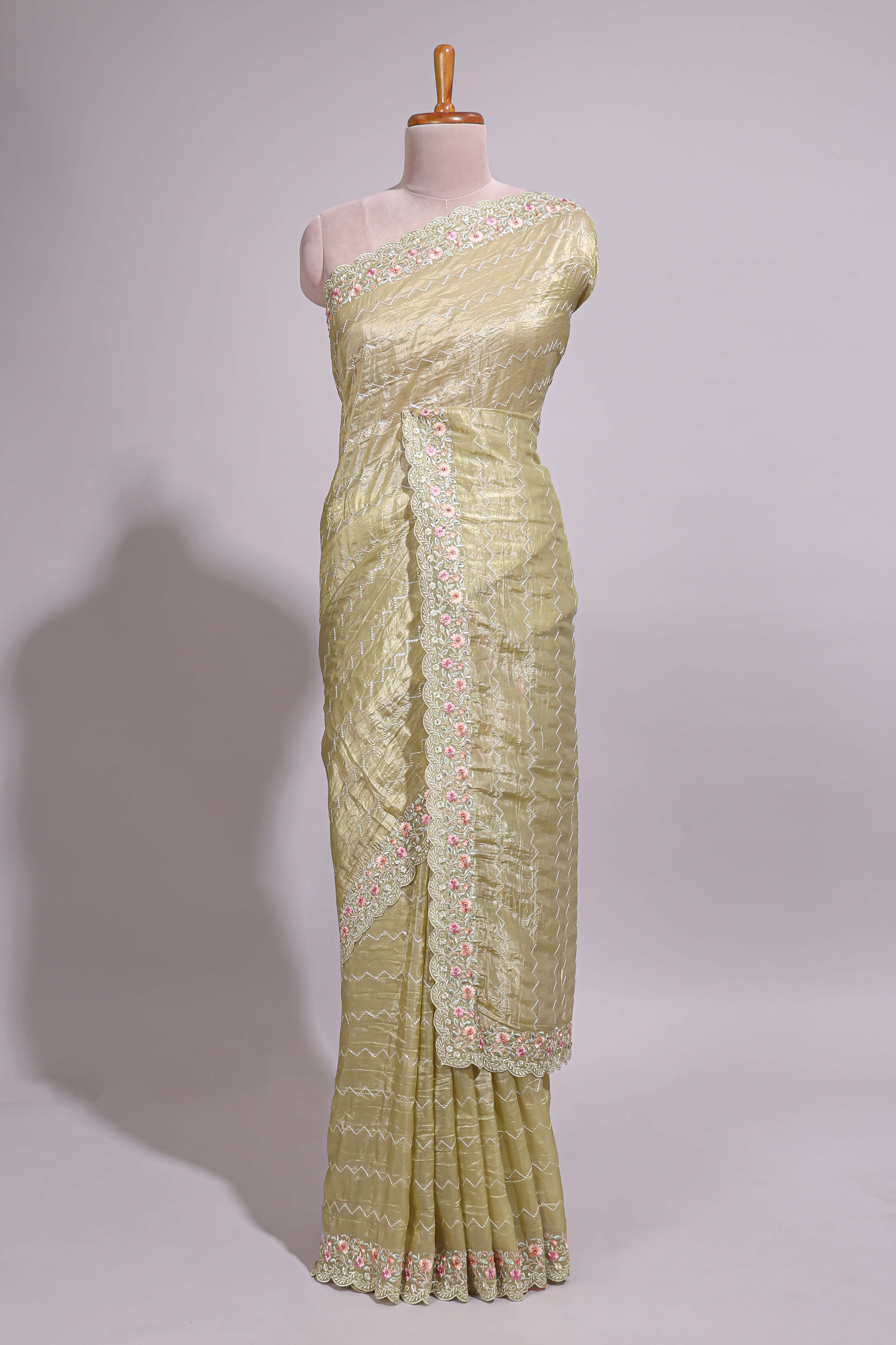 Pastel yellow organza saree featuring delicate floral embroidery intricate lace detailing on the border and pallu with a scalloped finishing along with matching blouse