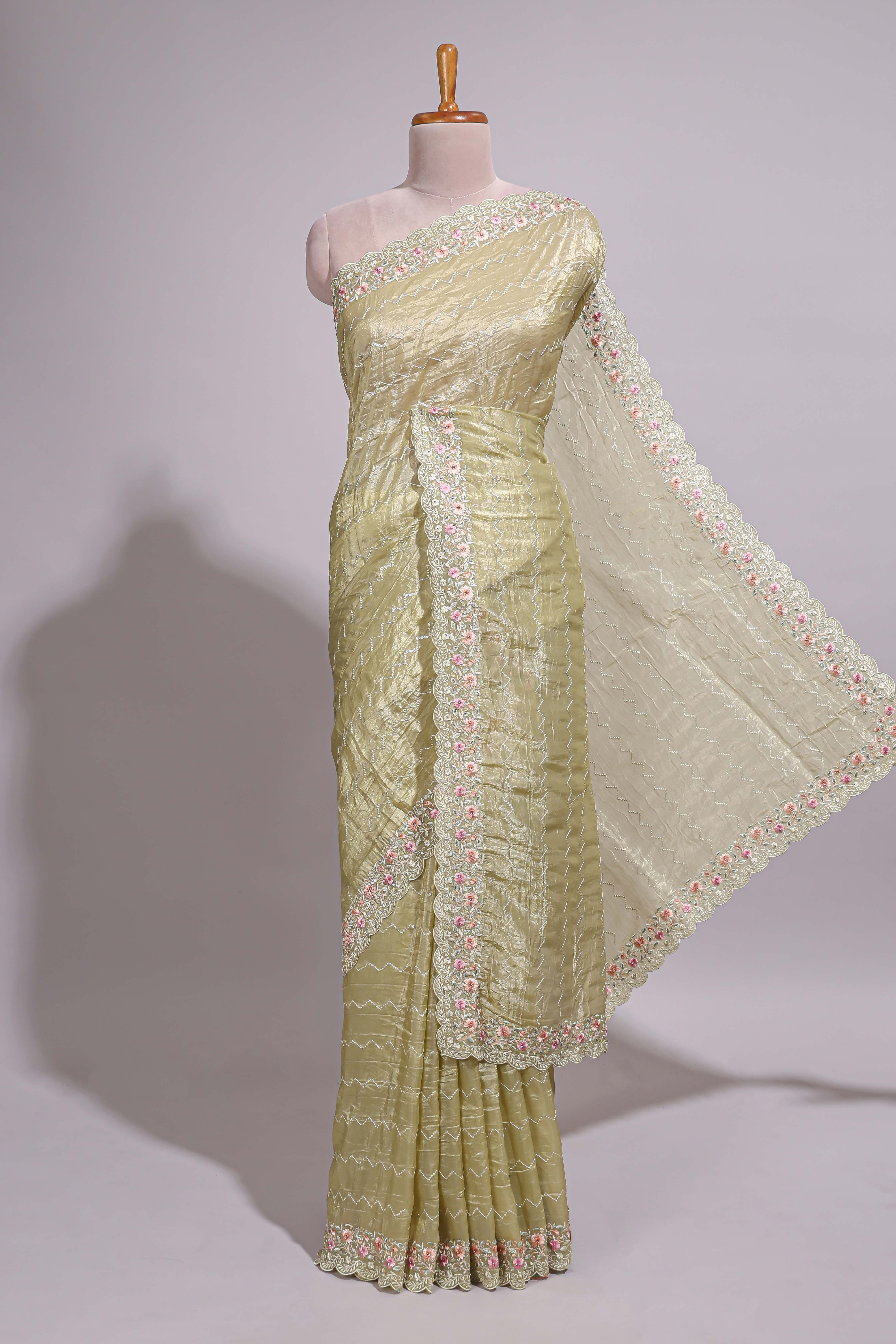 Pastel yellow organza saree featuring delicate floral embroidery intricate lace detailing on the border and pallu with a scalloped finishing along with matching blouse