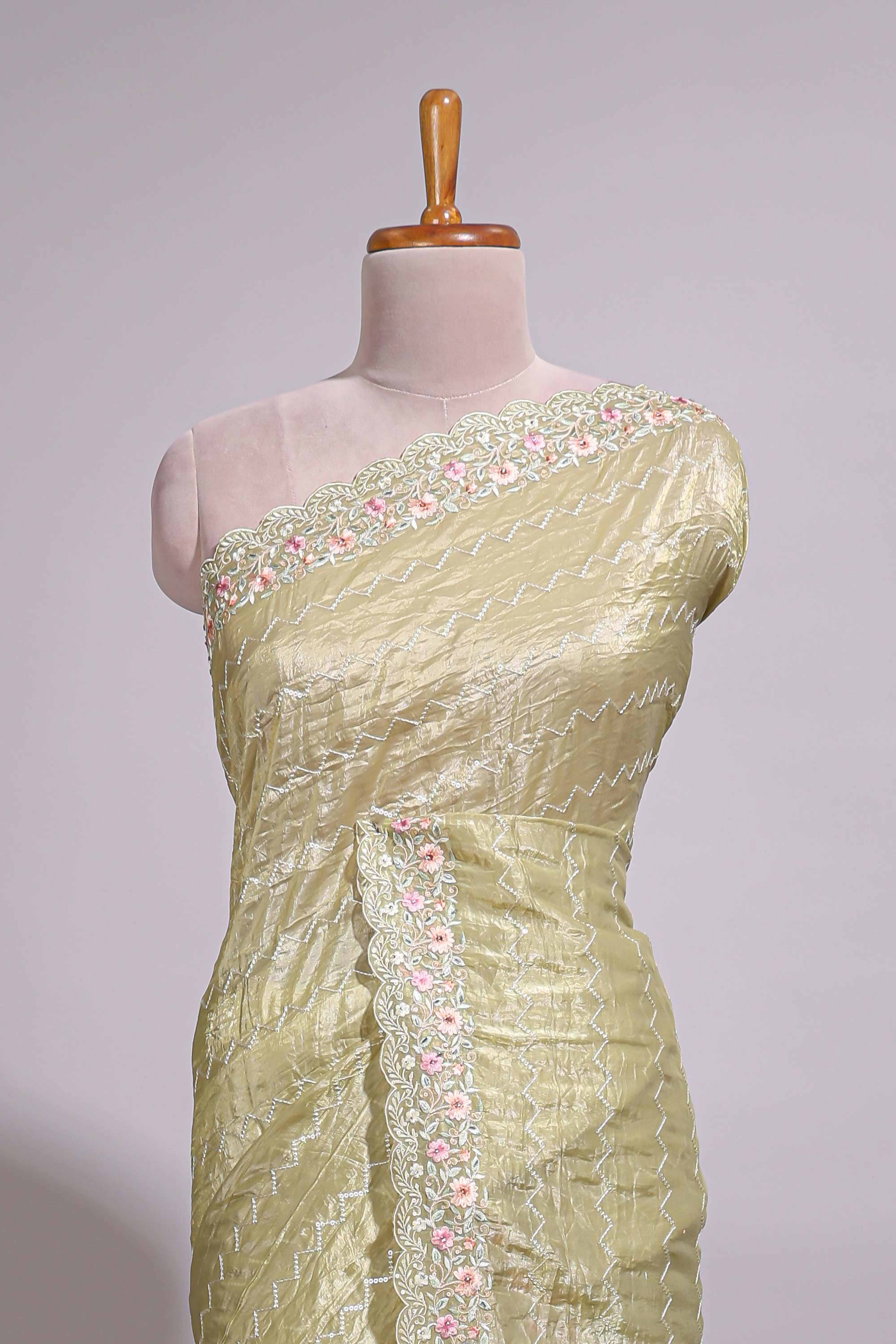Pastel yellow organza saree featuring delicate floral embroidery intricate lace detailing on the border and pallu with a scalloped finishing along with matching blouse