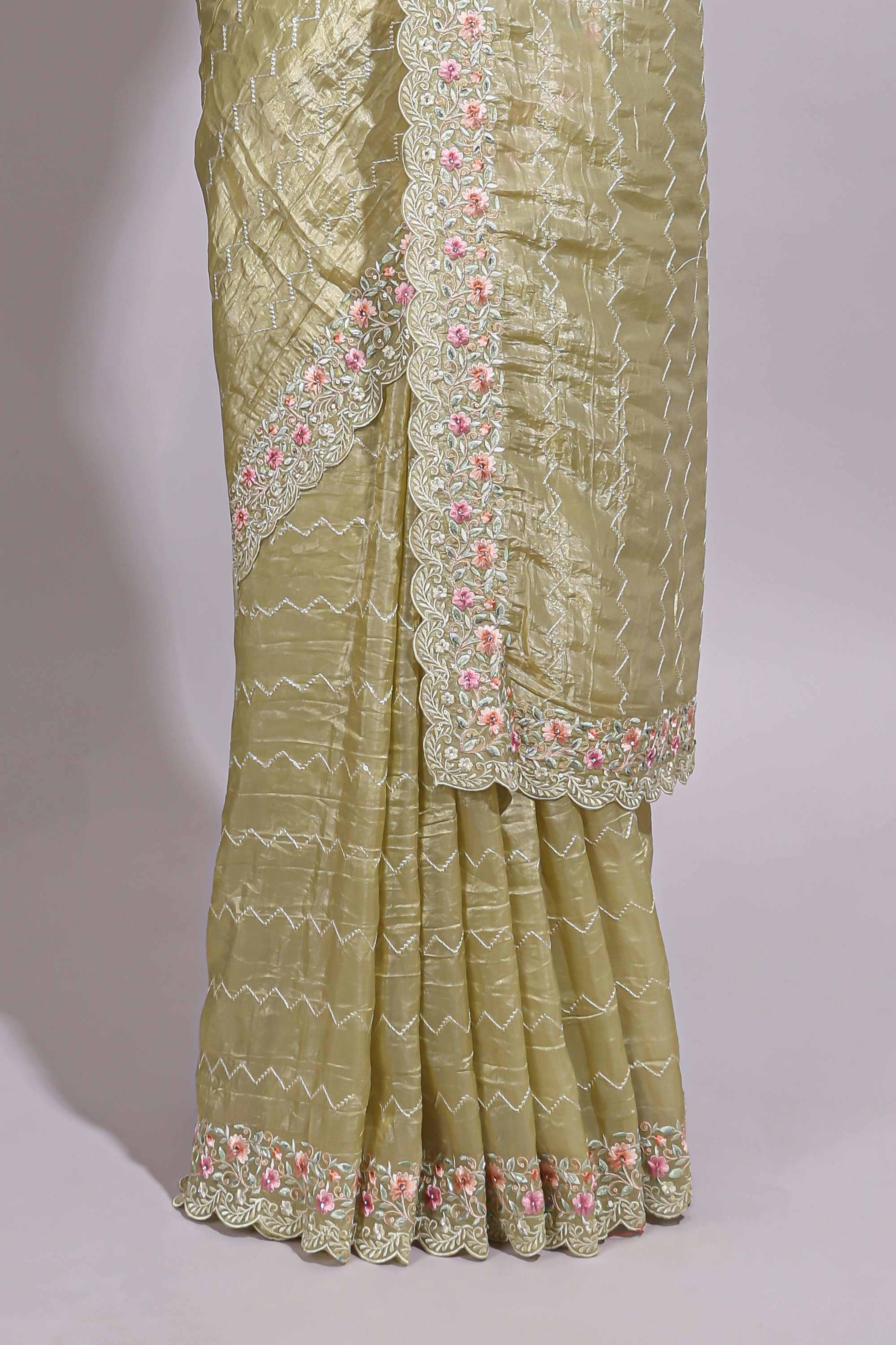 Pastel yellow organza saree featuring delicate floral embroidery intricate lace detailing on the border and pallu with a scalloped finishing along with matching blouse