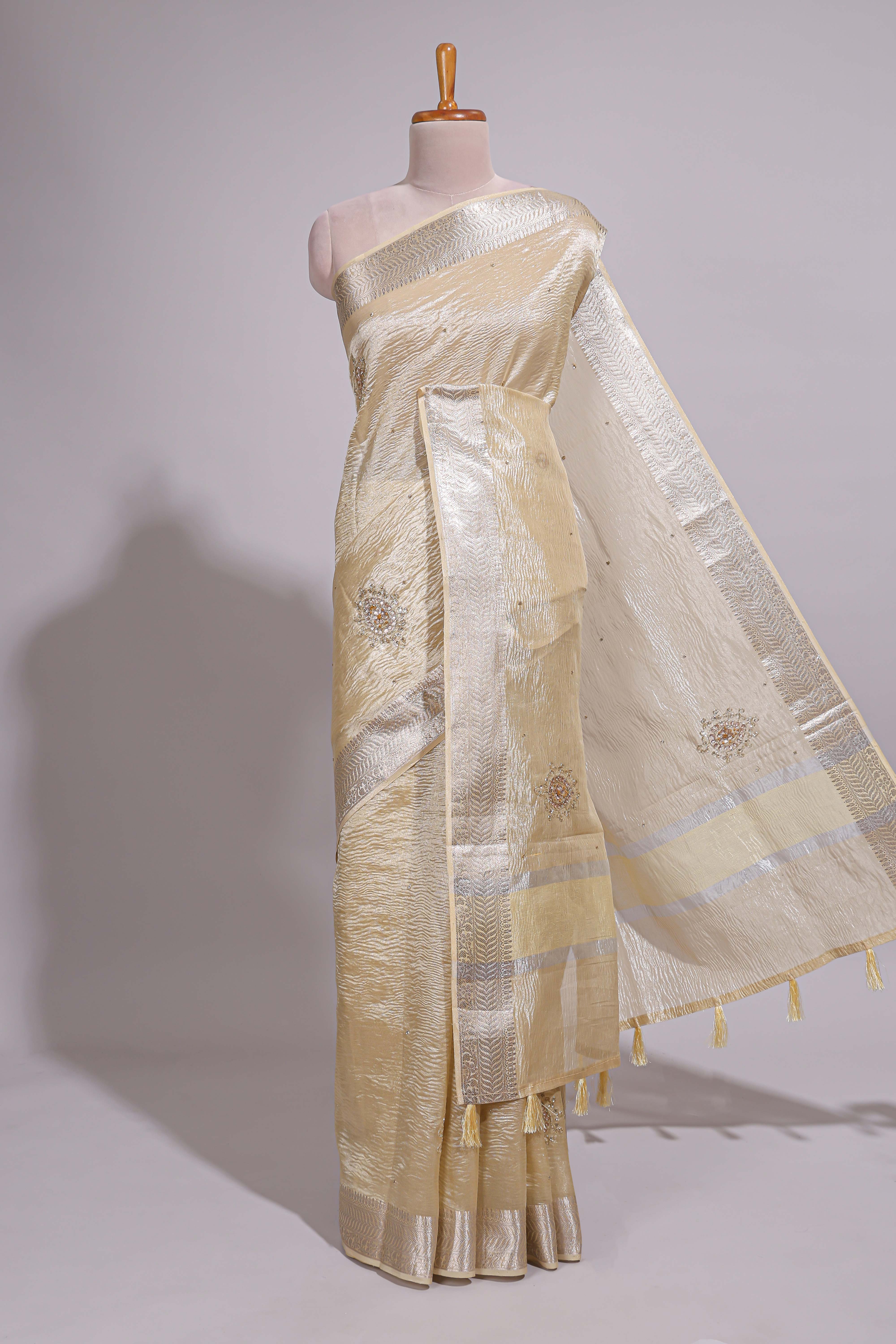 Cream organza saree featuring delicate floral embroidery intricate with silverborder along with blouse