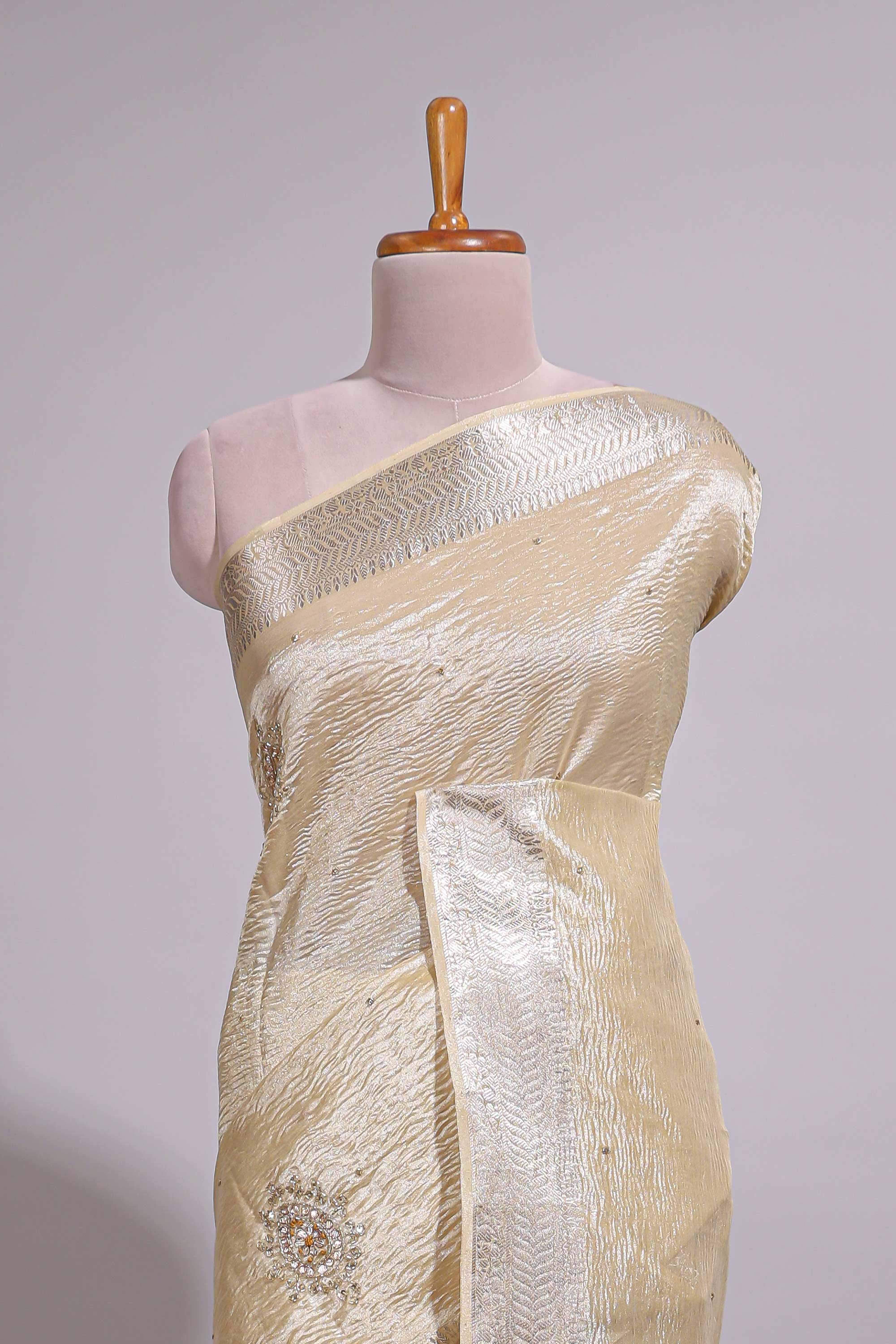 Cream organza saree featuring delicate floral embroidery intricate with silverborder along with blouse