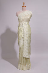 Pastel ivory organza saree with delicate floral embroidery intricate lace border and scalloped pallu detailing