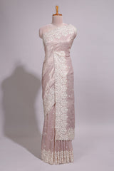 Soft blush pink organza saree with delicate floral embroidery intricate lace border and scalloped pallu detailing
