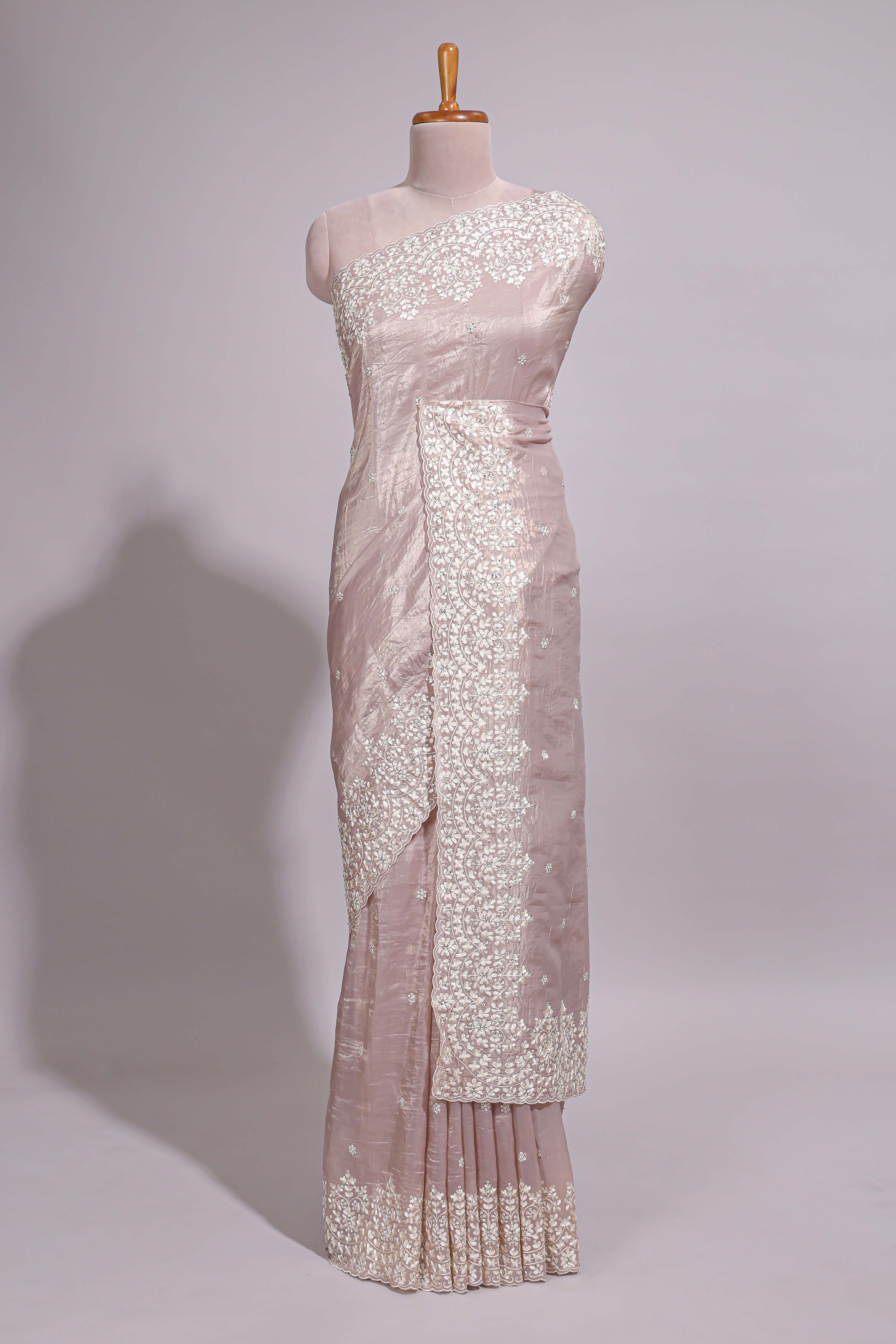 Soft blush pink organza saree with delicate floral embroidery intricate lace border and scalloped pallu detailing