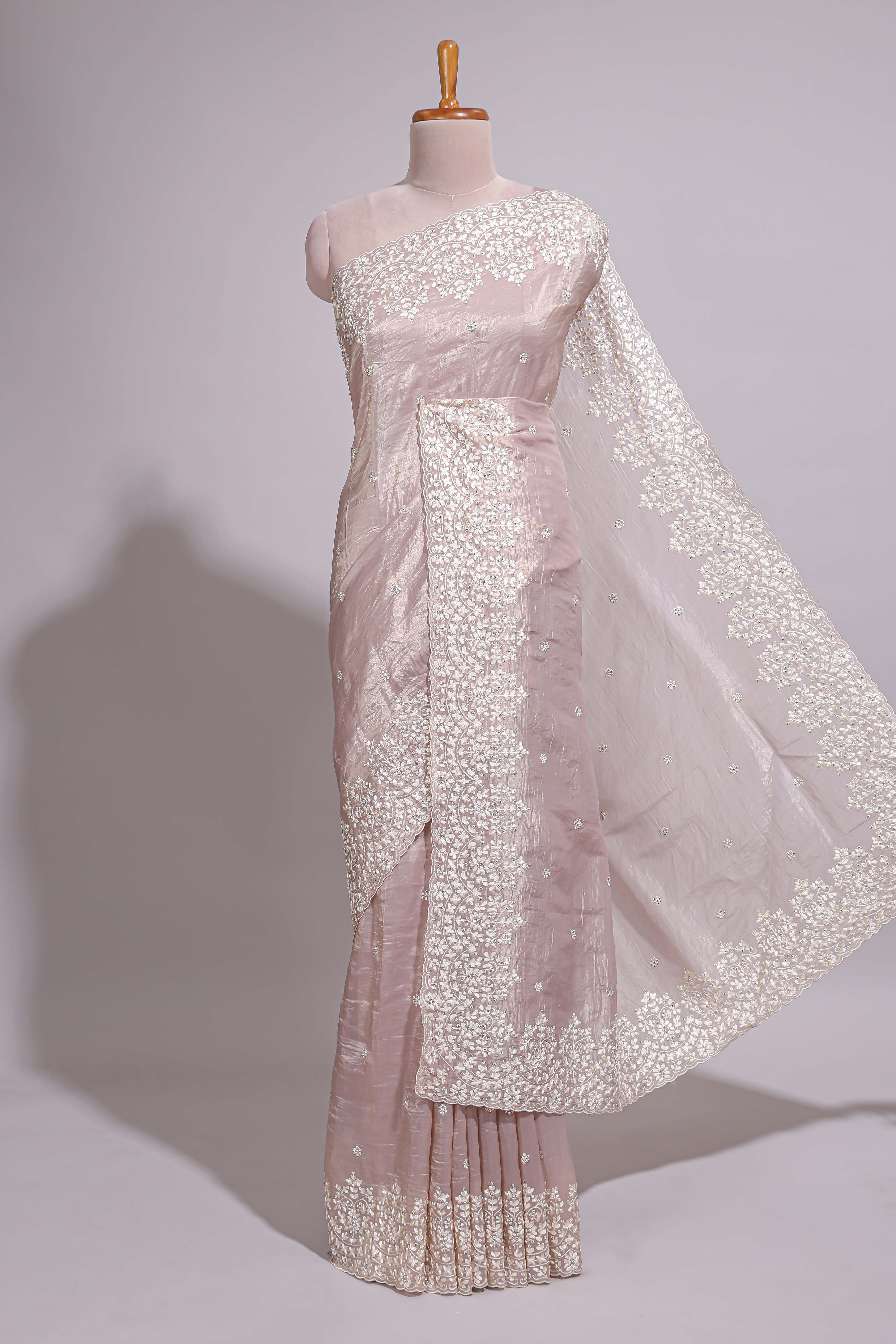 Soft blush pink organza saree with delicate floral embroidery intricate lace border and scalloped pallu detailing